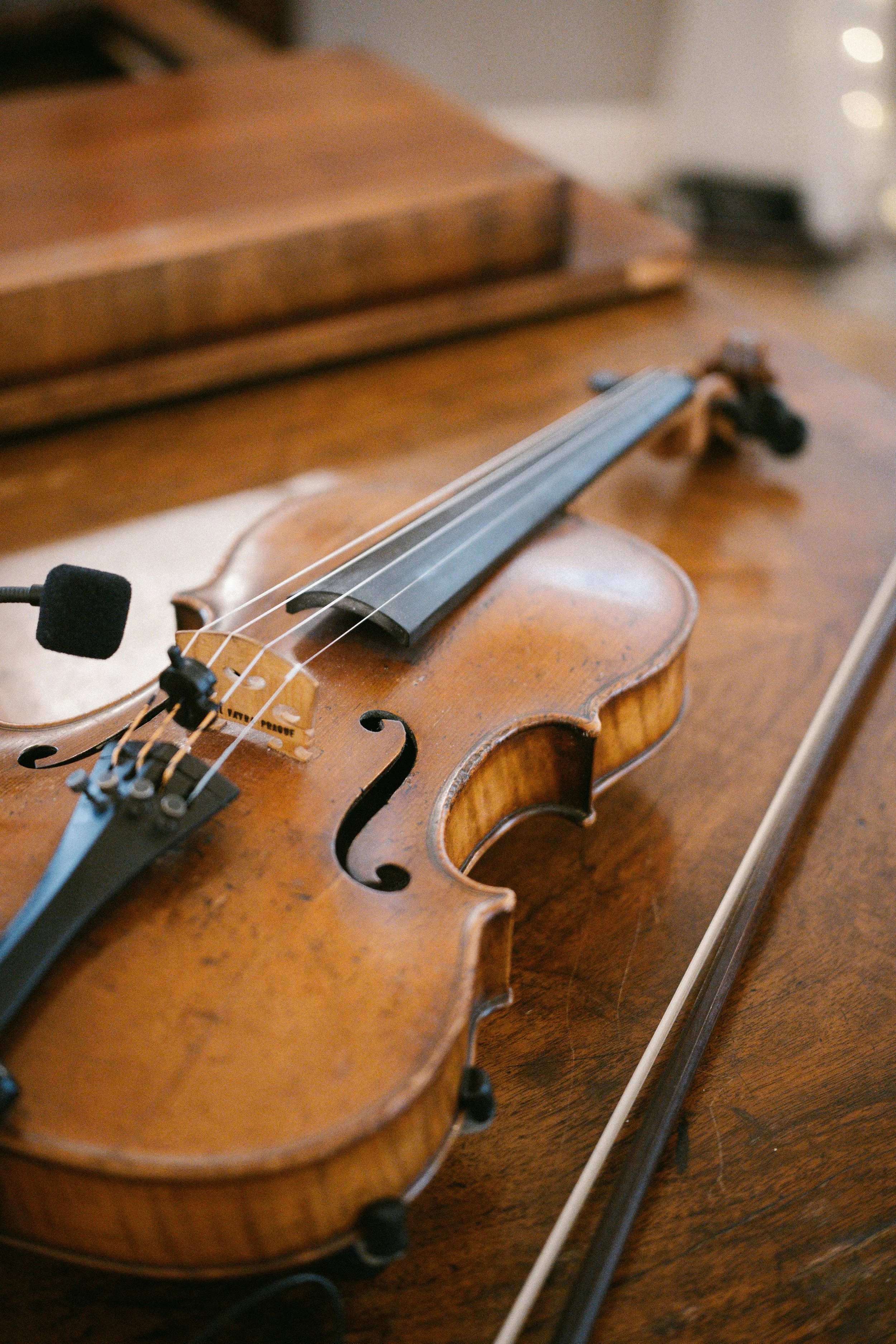 Close-up of a wooden violin resting on a wooden surface.