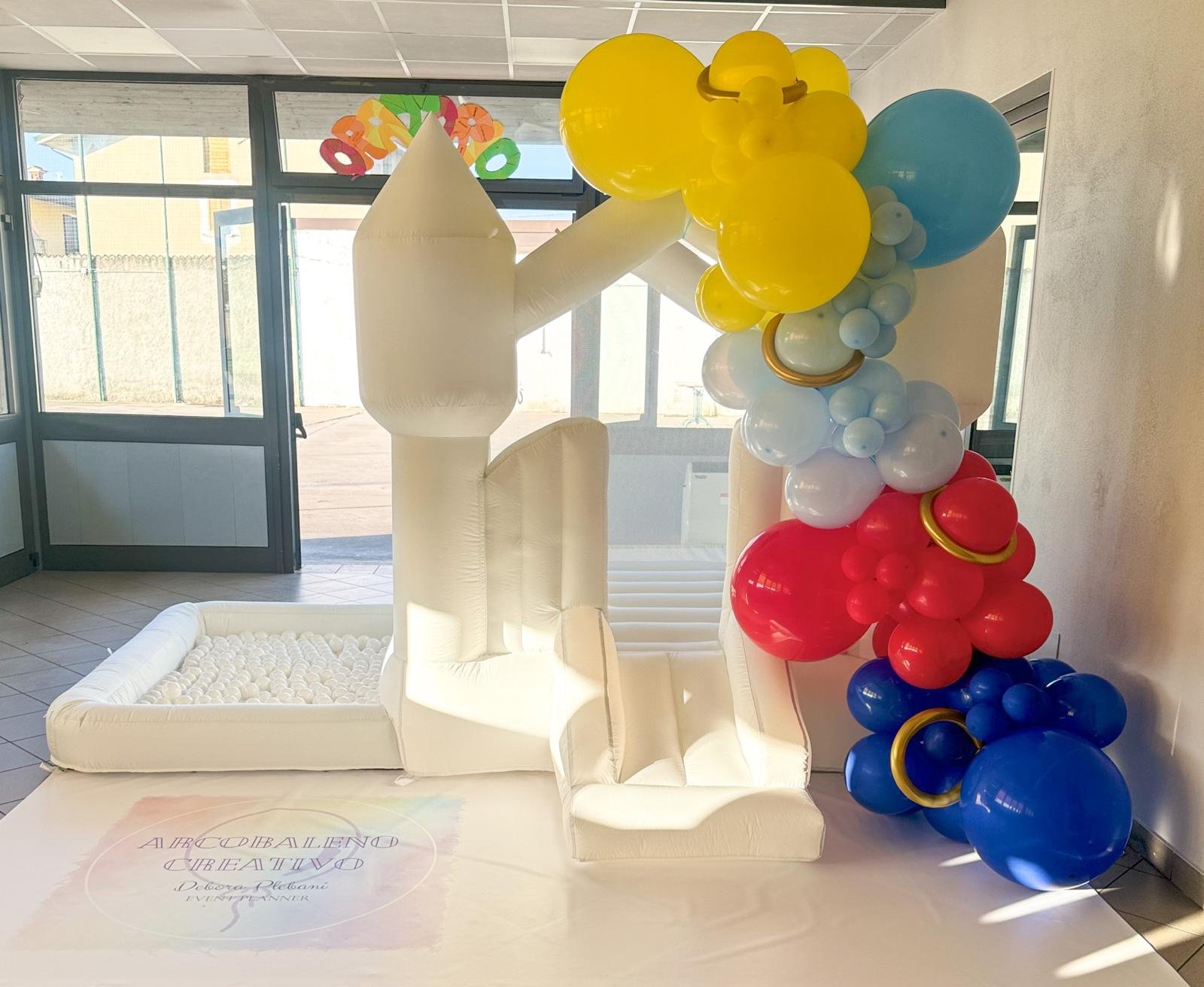 Decorazione con palloncini colorati e grande numero 4 gonfiato, in un'area interna con porte e finestre