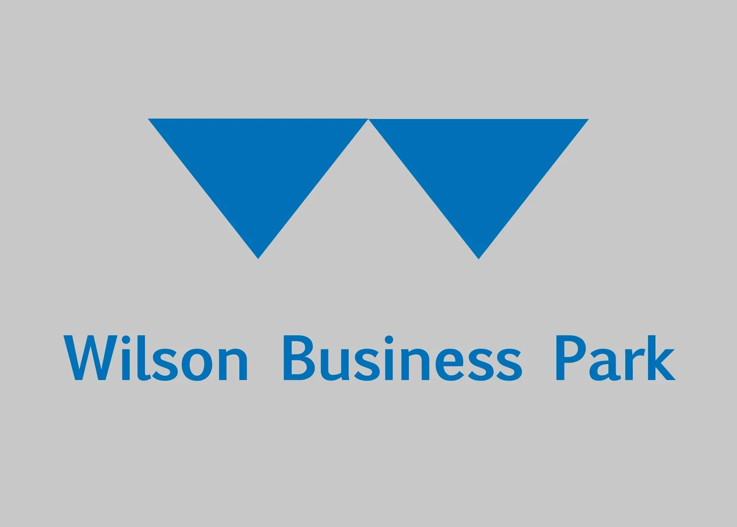 Logo with two blue triangles pointing downward above the text "Wilson Business Park" in blue on a gray background.