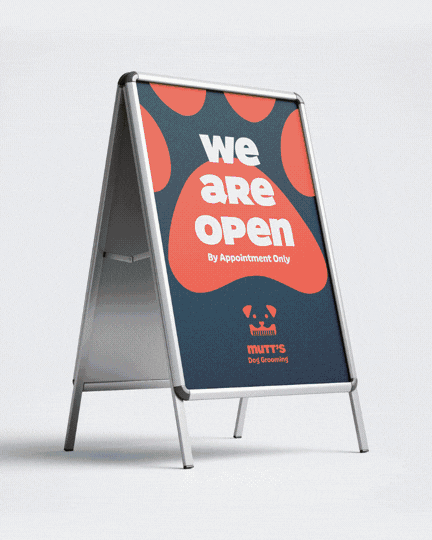 A-frame signboard with a sign that reads "We Are Open" for Mutts Day Grooming, featuring a logo of a dog face with a bowtie and the text "by appointment only."