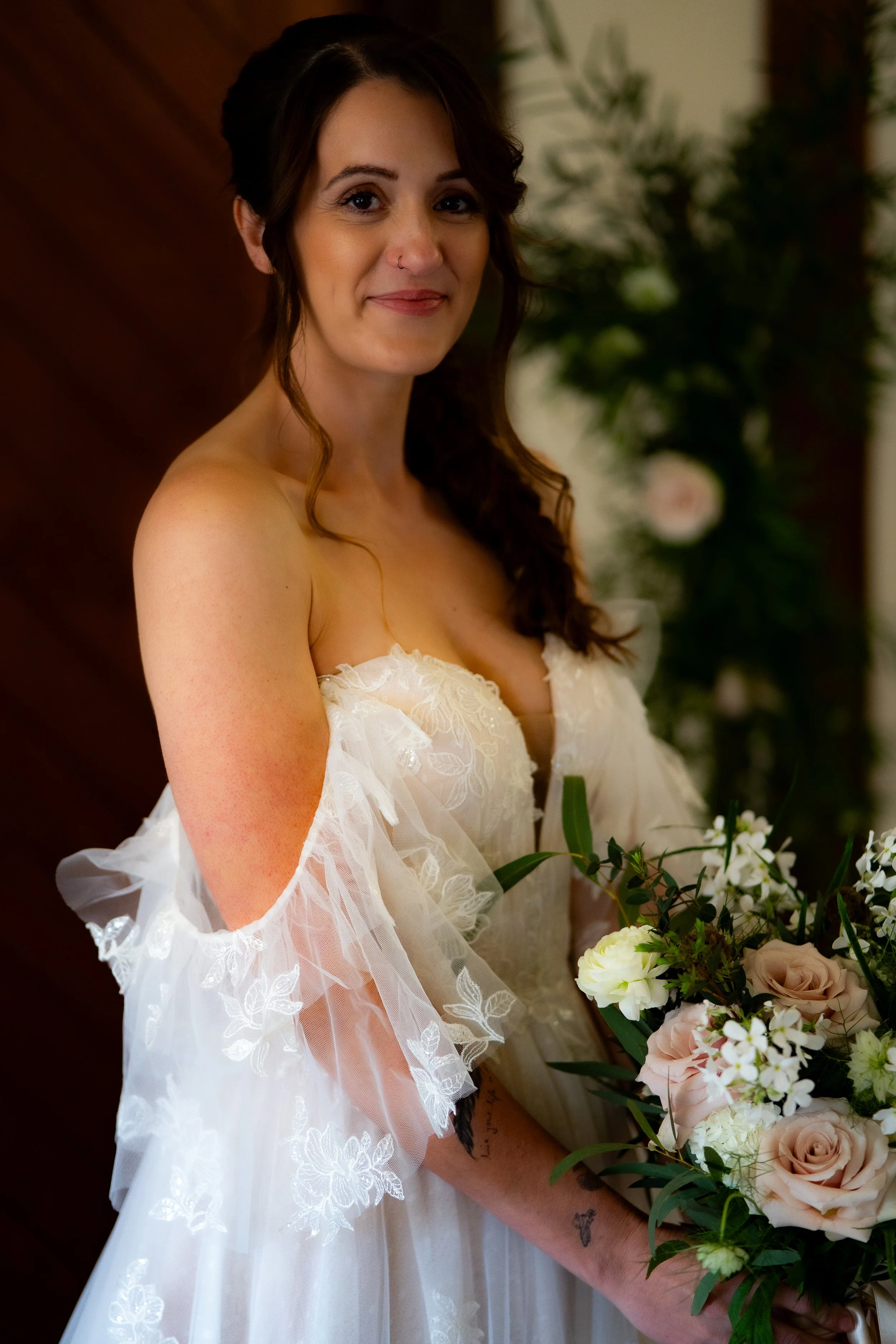 A woman in a wedding dress holding a bouquet of flowers.