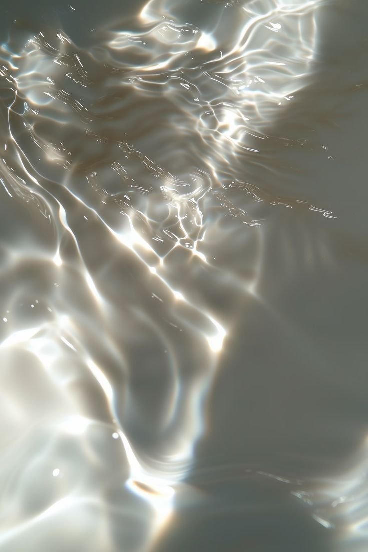 Close-up of shimmering water surface with light reflections and ripples.