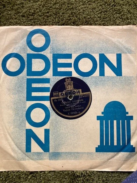 Vintage Odeon record with a paper sleeve displaying the Odeon logo and a graphical illustration of a building or monument.