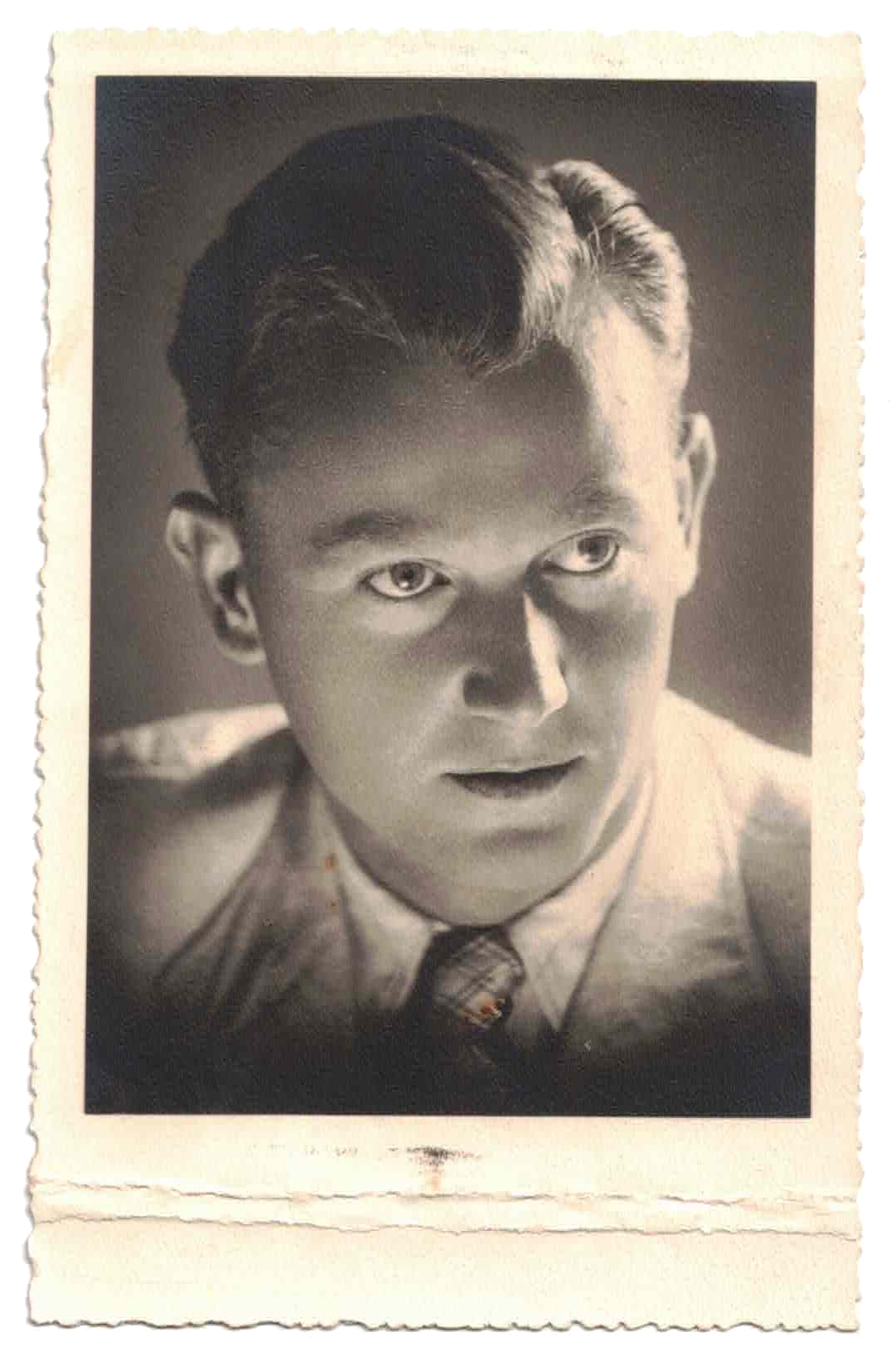 Black and white portrait of a young man with neatly combed hair, wearing a collared shirt and tie.