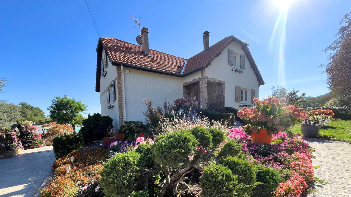 une maison au sein d'un jardin fleuri avec façade rénovée