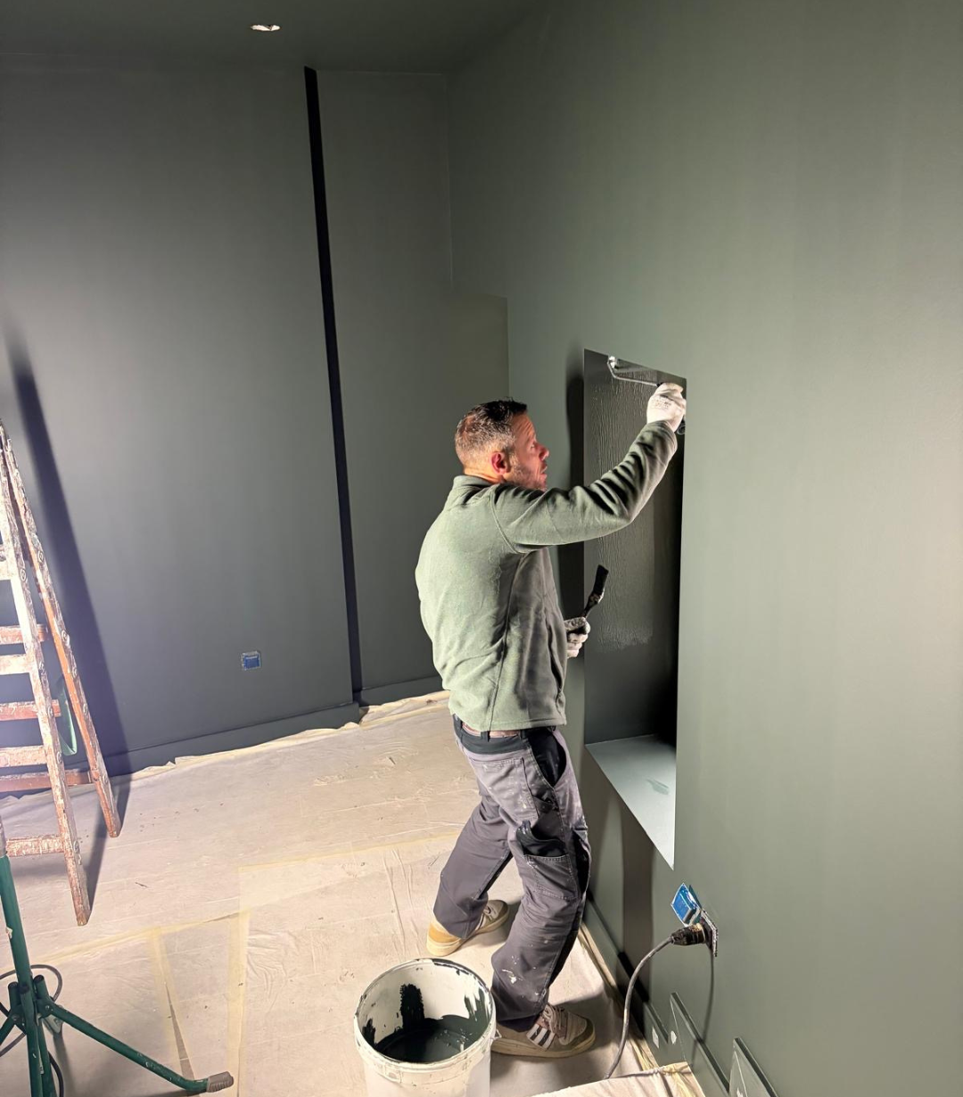 un peintre entrain d'appliquer peinture farrow & ball