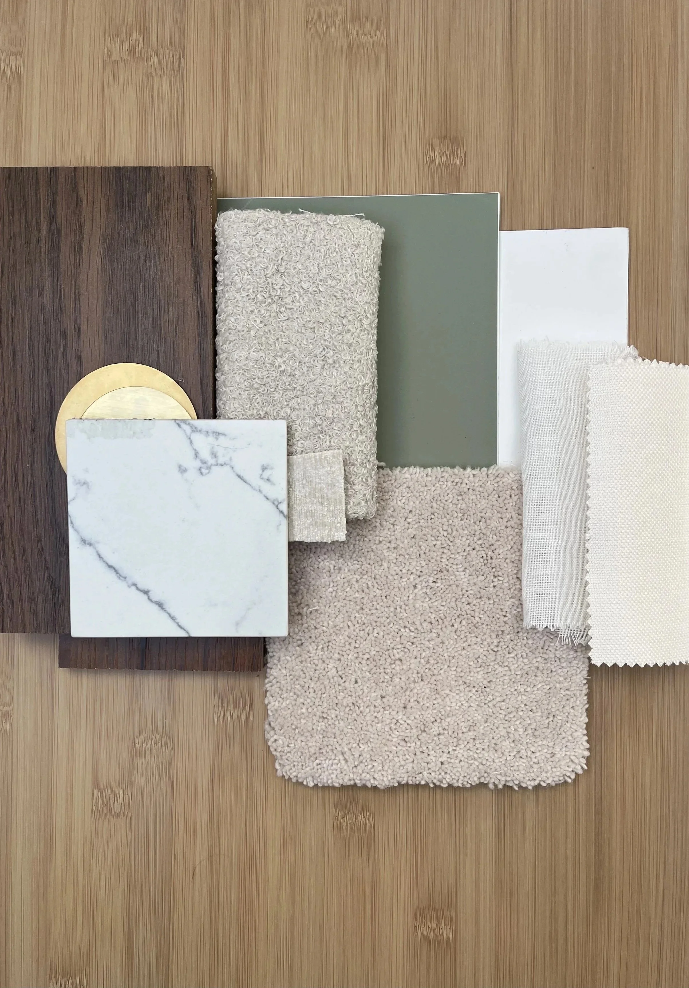 Materials finish board layering timber, marble, fabric, carpet and paint samples across a timber surface — Susan Cotter Design material palette.