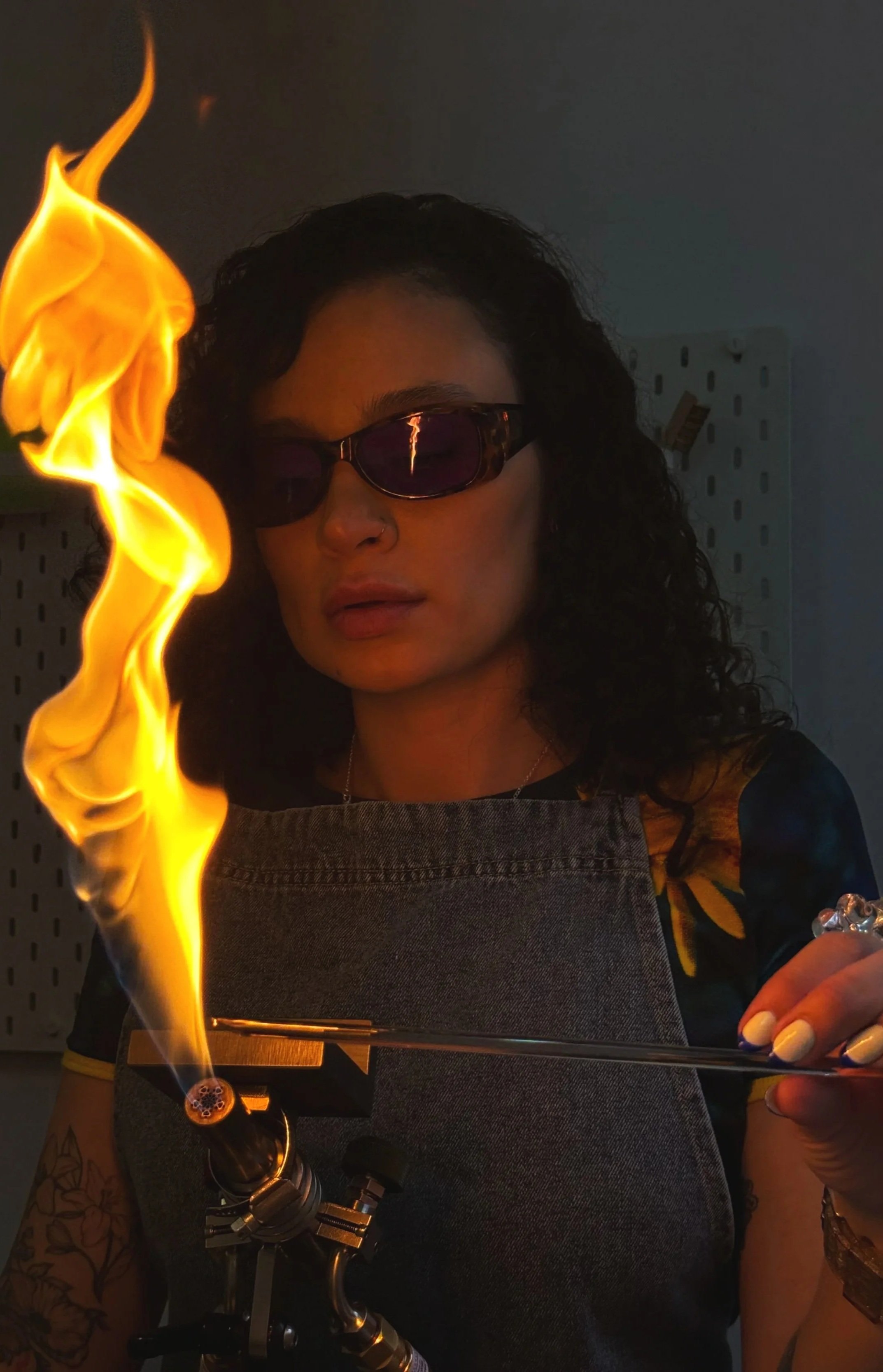 mujer trabajando con coplete para derretir vidrio y crear joyeria. alquiler de soplete y espacio para trabajar con vidrio