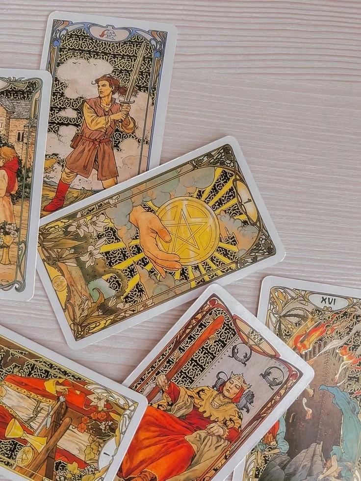Jeux de cartes de tarot avec des illustrations symboliques et colorées, représentant des figures mythologiques et des scènes mystérieuses.