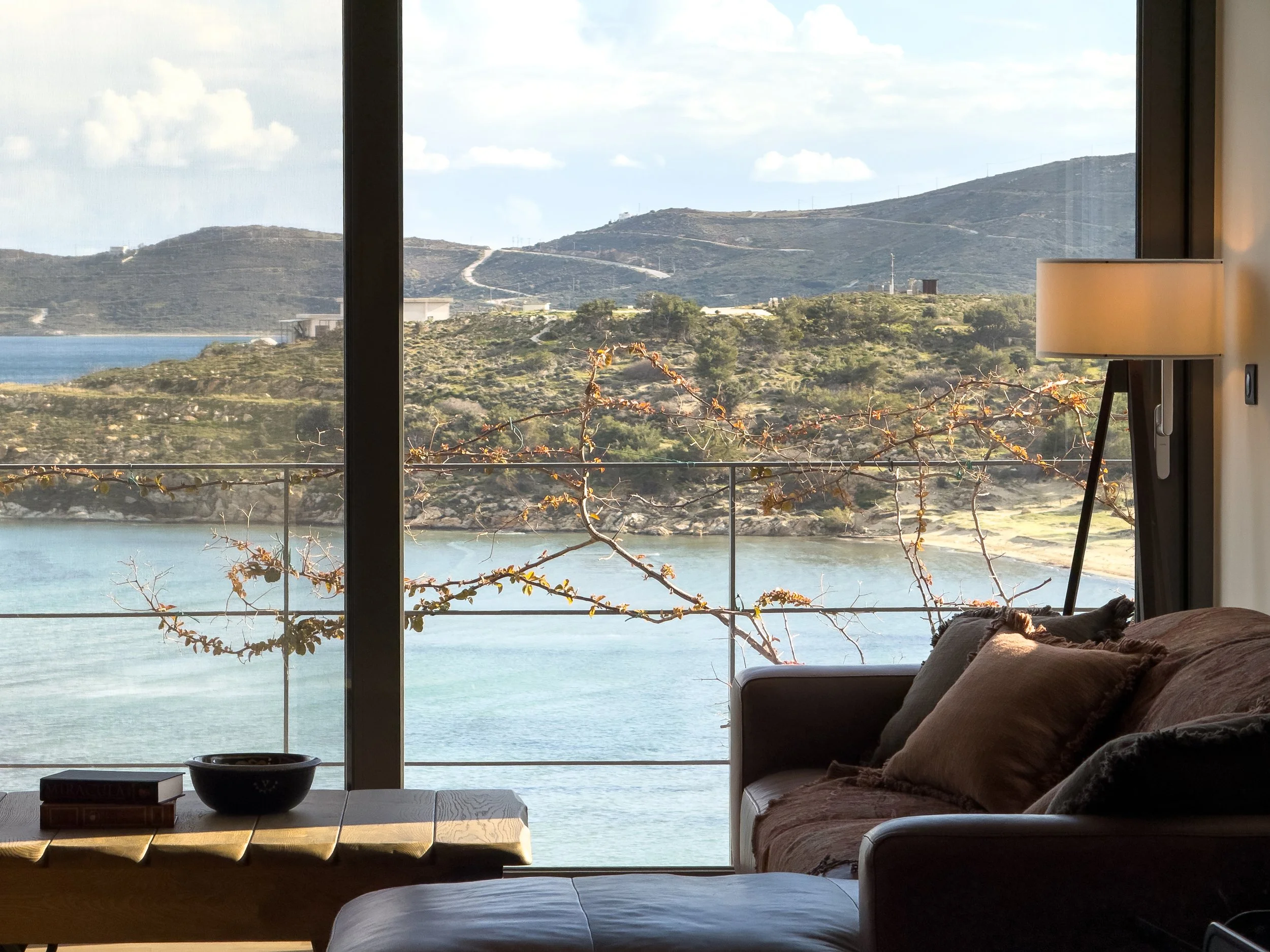 Warm living interiors with panoramic landscape views at Astraea Villa.