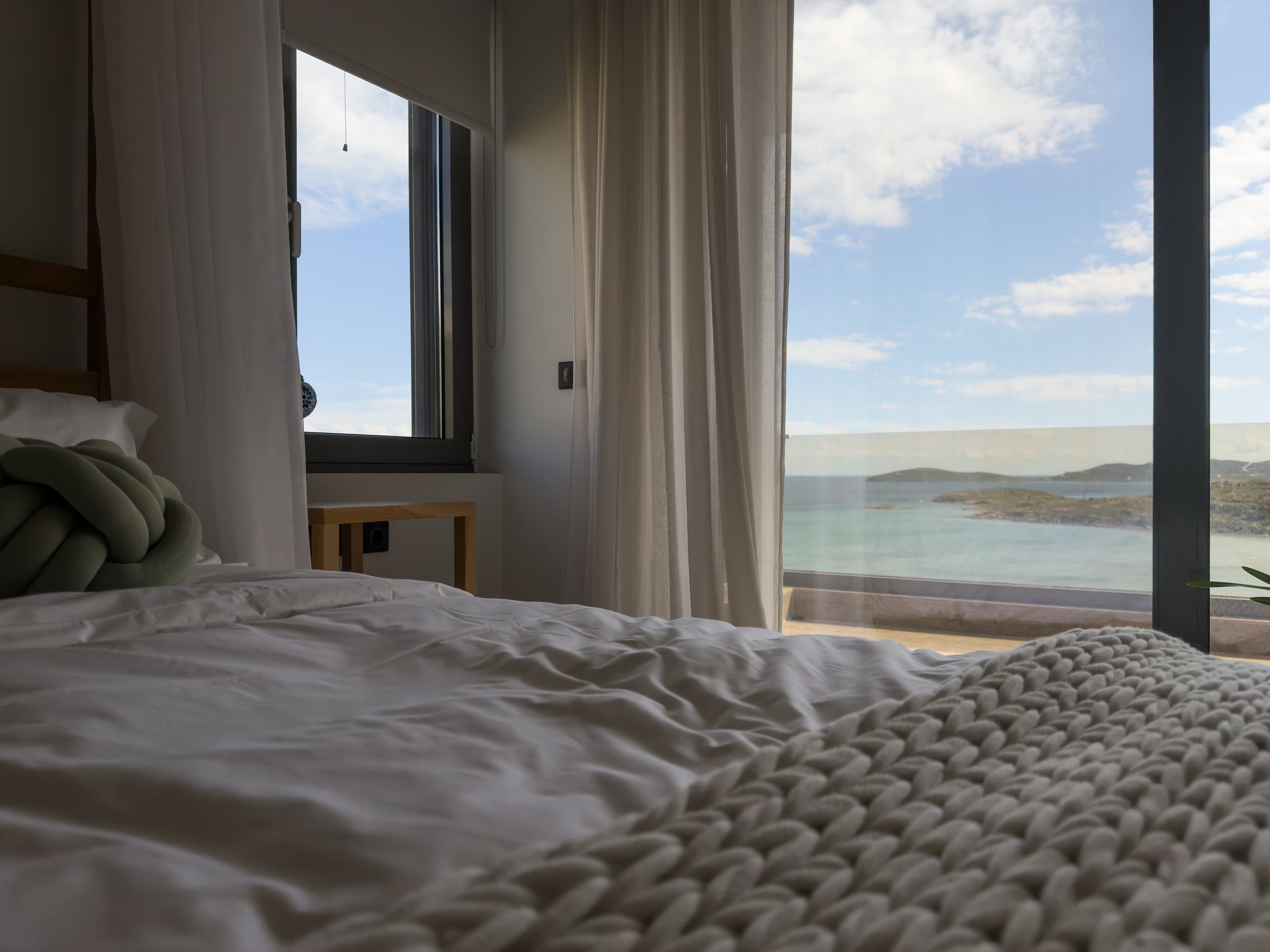 Restful bedroom space with panoramic sea views at Astraea Villa