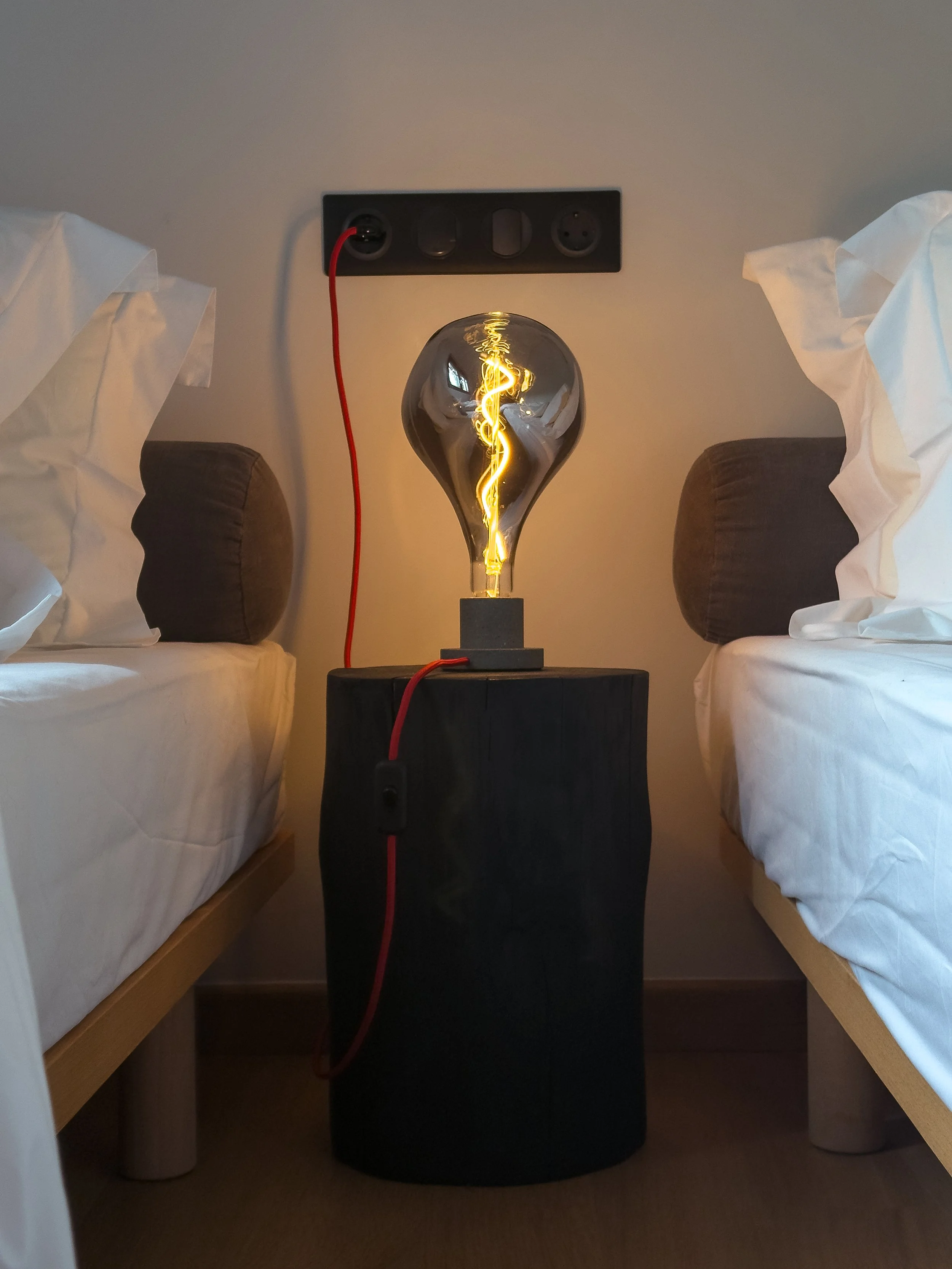 Warm Edison-style lighting detail with intimate bedroom atmosphere at Astraea Villa.
