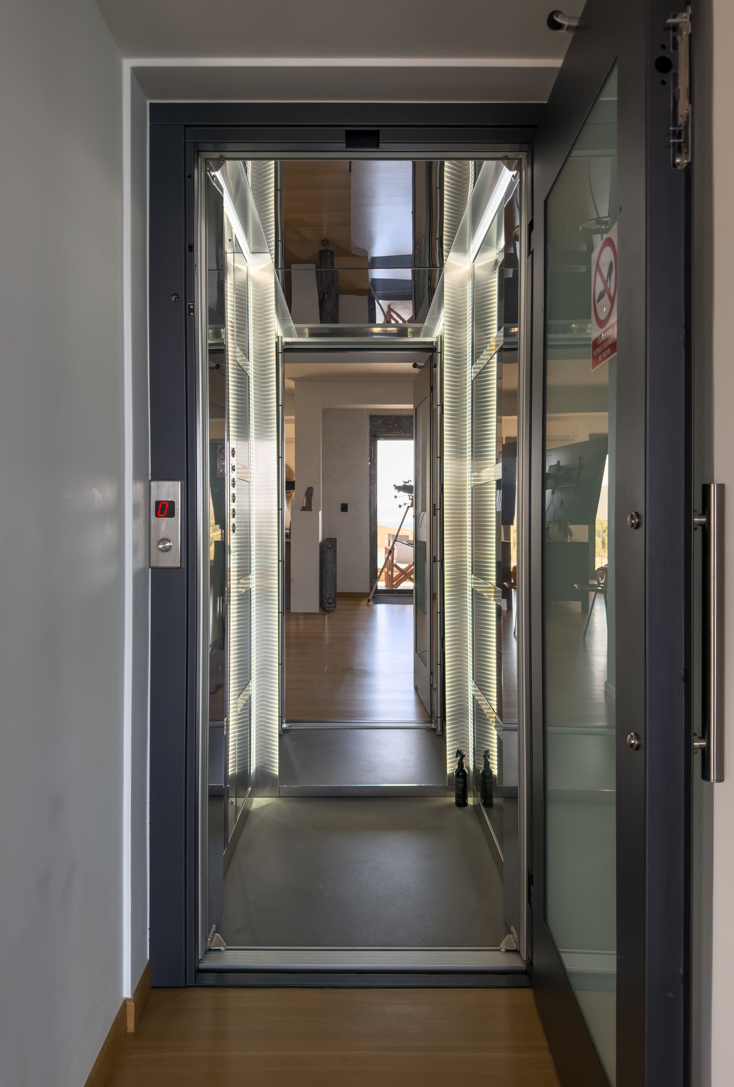 Modern elevator interiors with reflective textures and refined architectural flow at Astraea Villa.