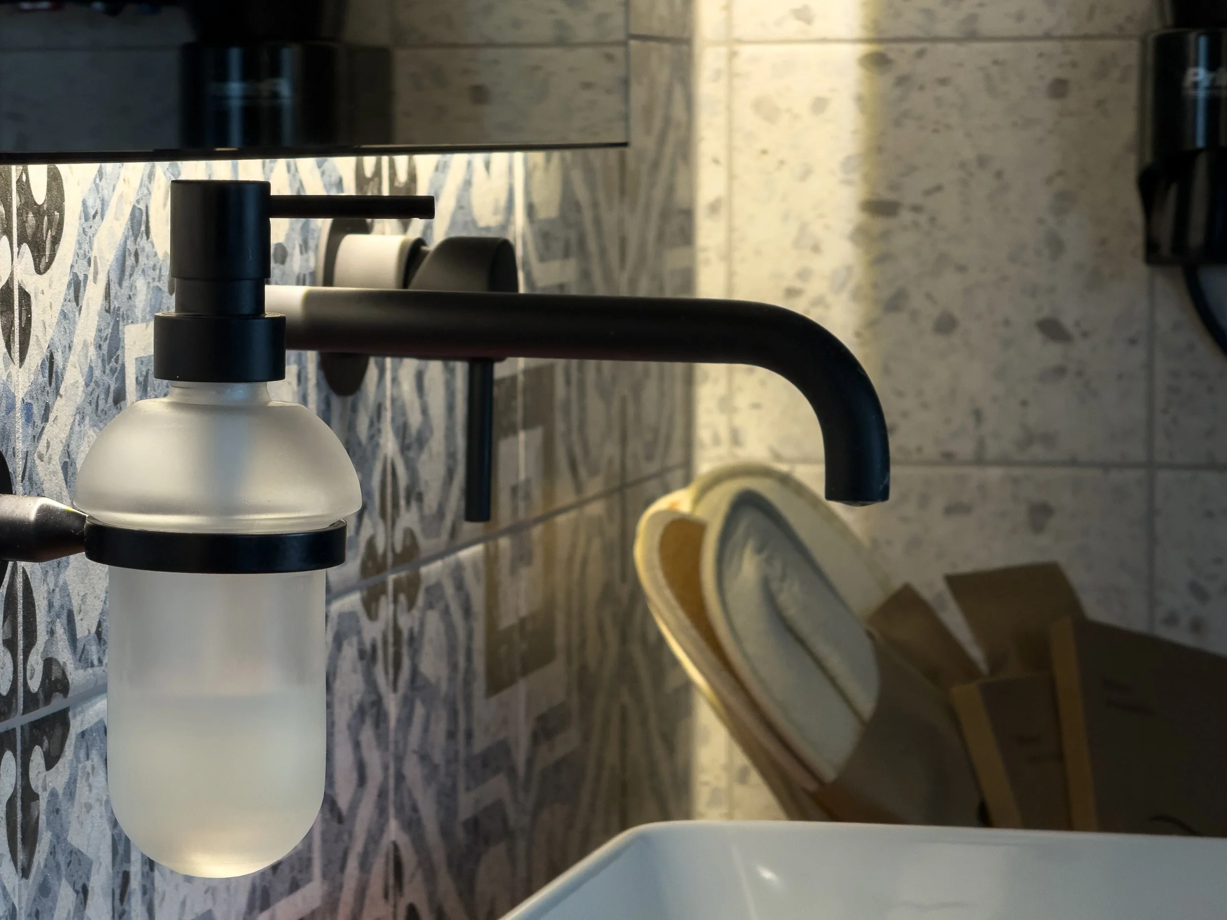 Minimal bathroom detail enriched by patterned textures and contemporary simplicity at Astraea Villa.
