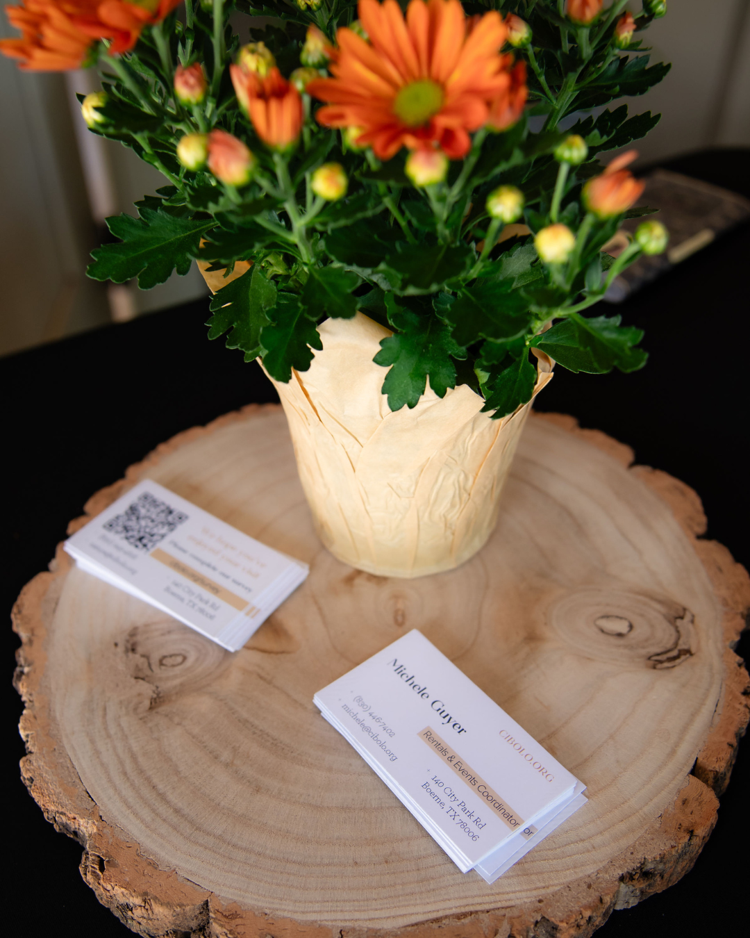 Business cards and floral arrangement on wooden table
