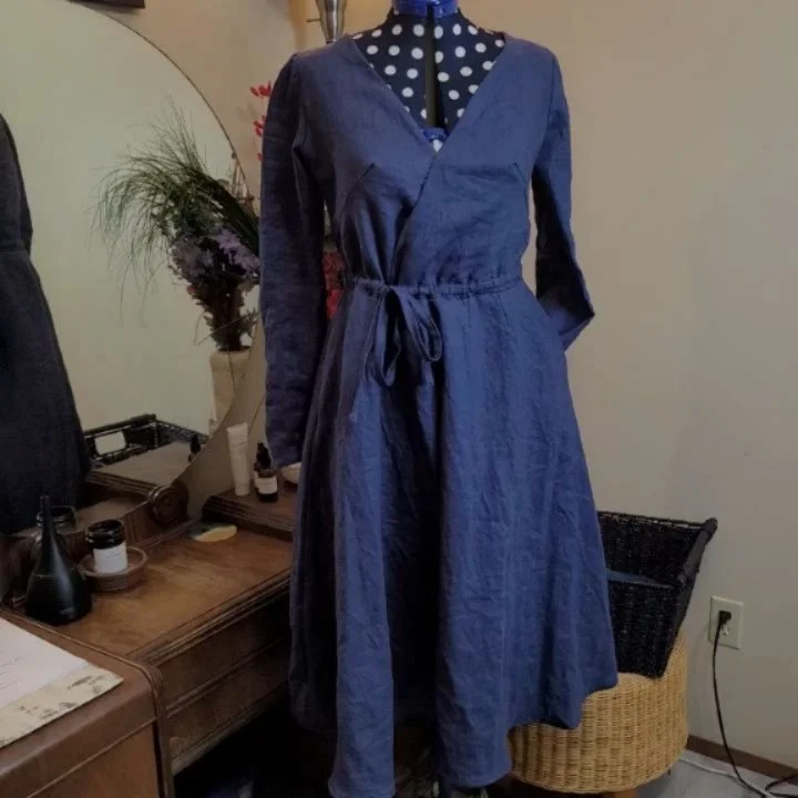 "Yve" Linen Dress
Designed with French darts, wrap front, shoulder detail, deep pockets, waist tie, &amp; long sleeves that easily roll up. Lovely midnight blue linen, as well as linen lining - becoming ultra soft in the years to come.

A n