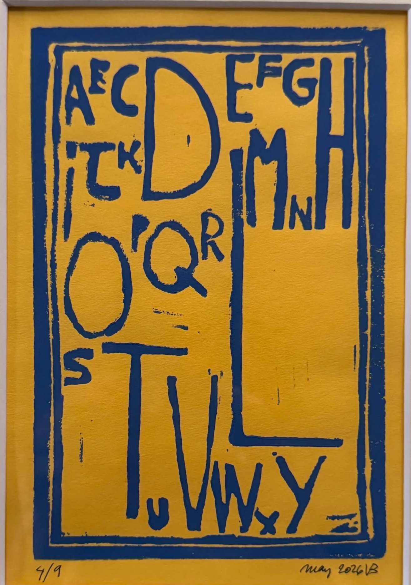 An abstract artwork with a yellow background and blue outline of text and shapes, featuring handwritten elements at the bottom. The text is stylized and appears fragmented.