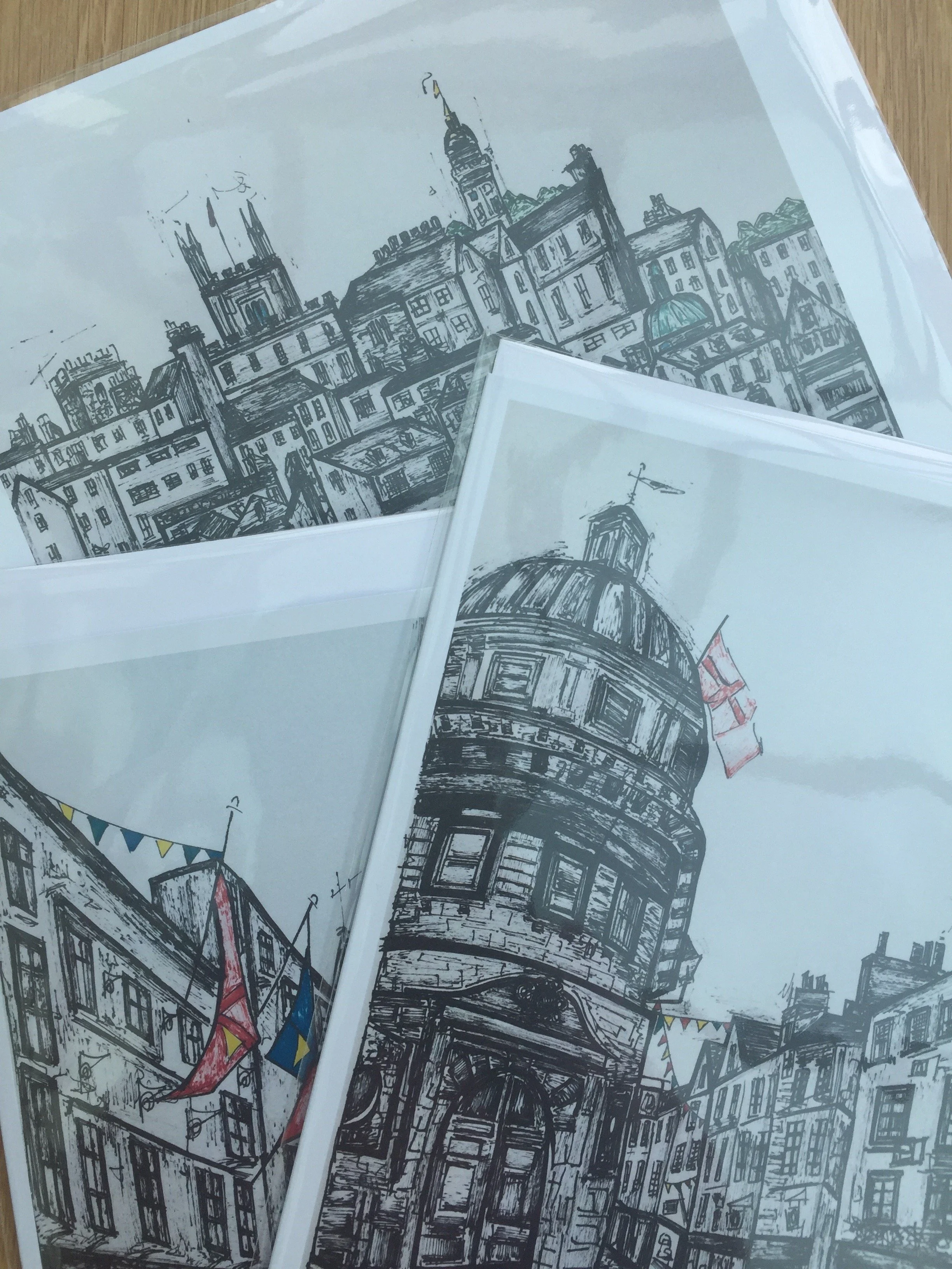 Black and white sketches of historic European cityscapes, including prominent domed buildings and clock towers, with some sketches partially covered by transparent plastic sheets.
