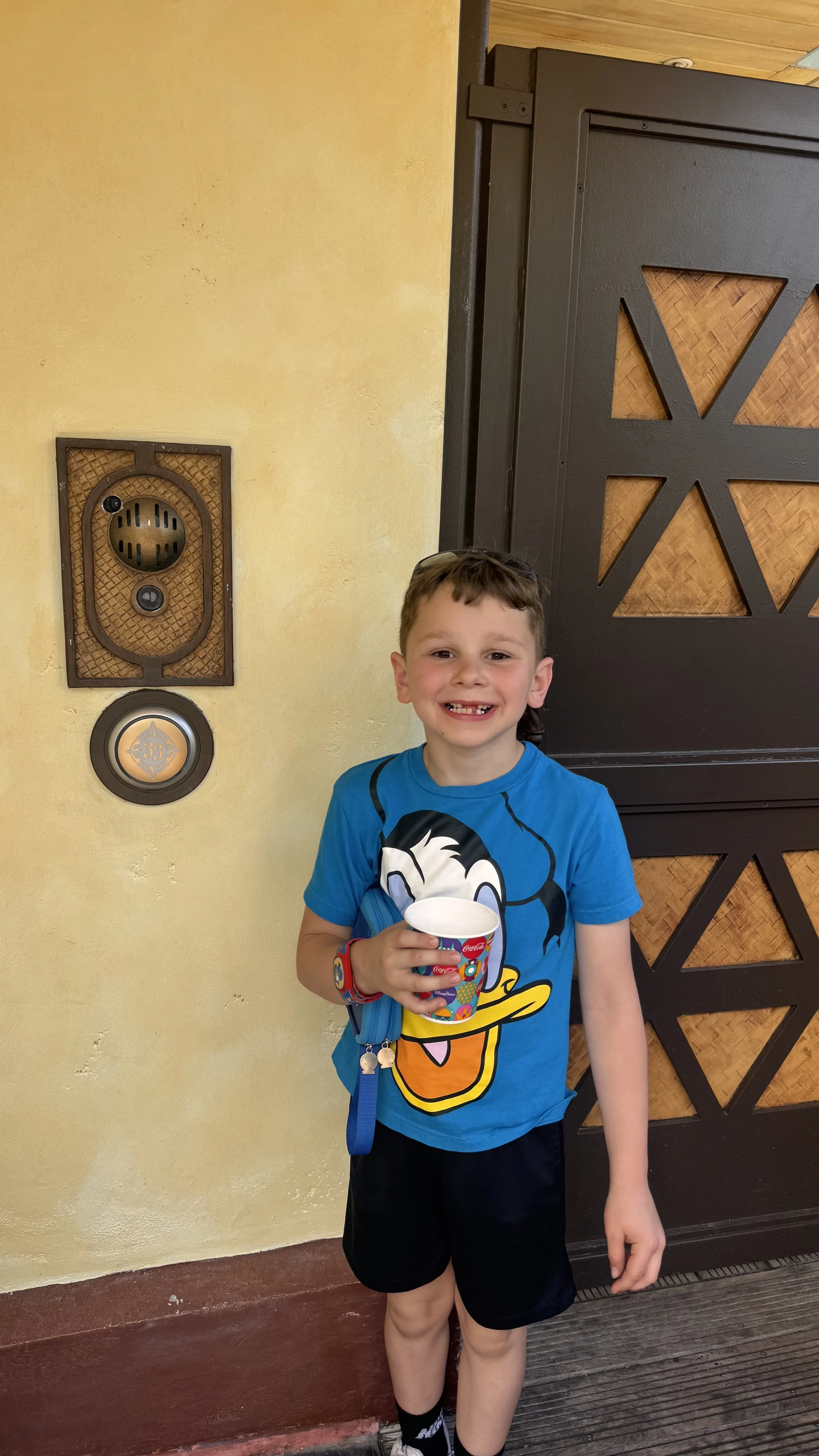 Jed sipping ice water in front of the Magic Kingdom Club 33 entrance area