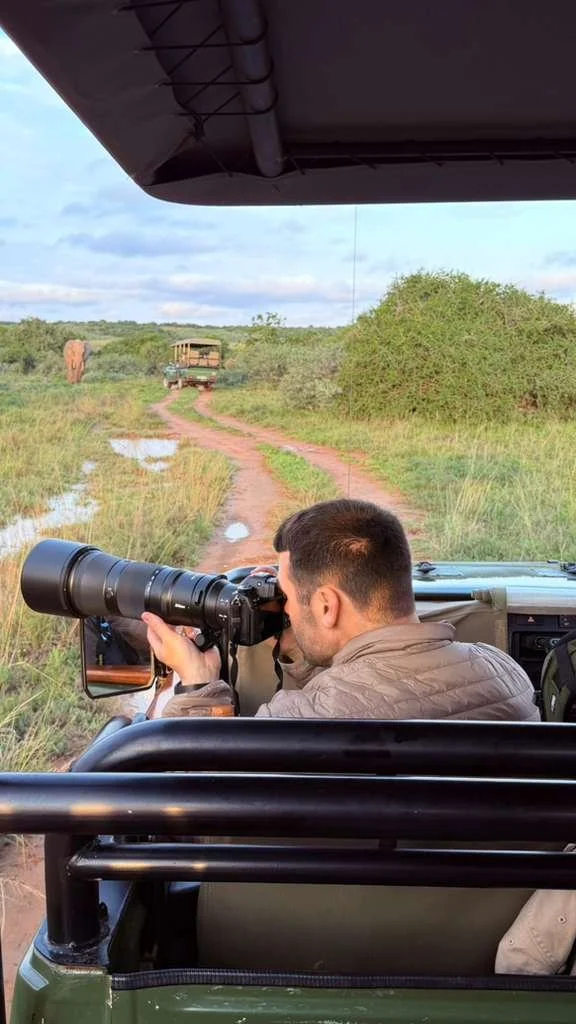 Man, in a safari jeep, its cold, with a camera with a long lens, Nikon Z6 III