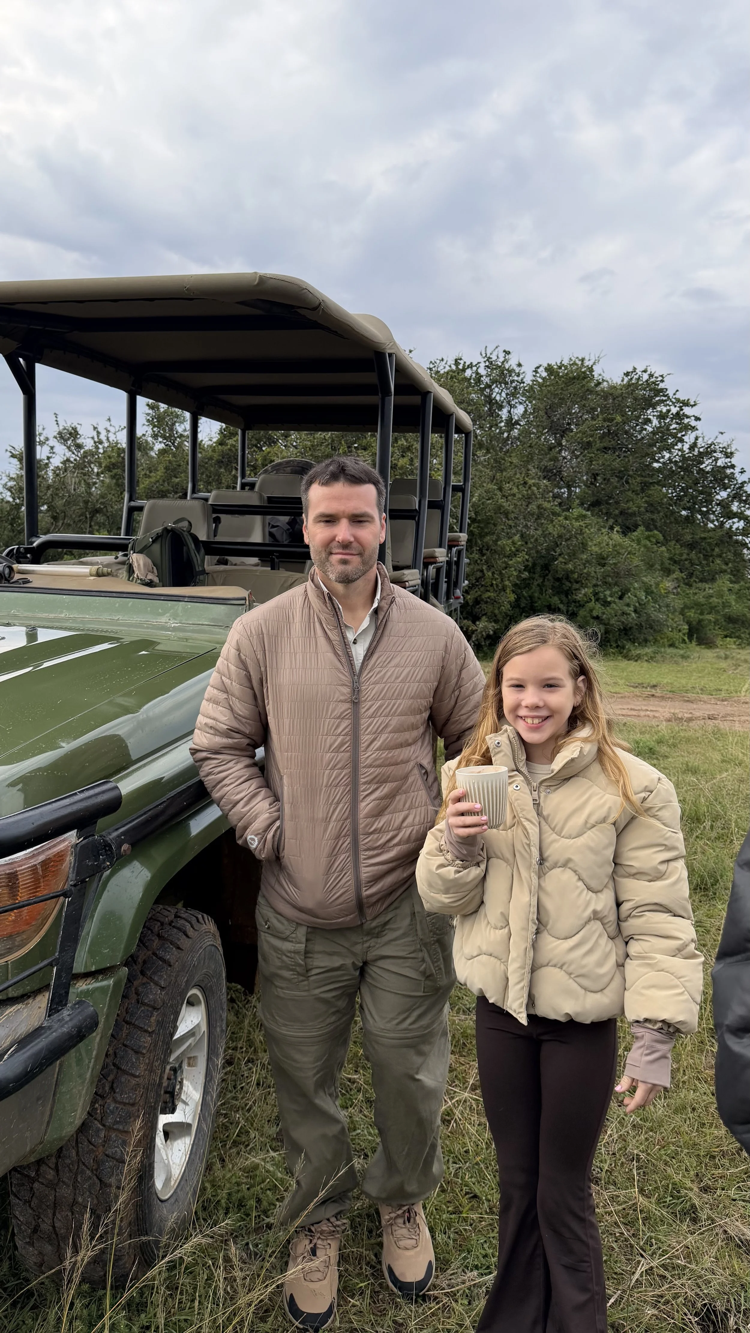 Father and daughter having coffee and hot chocolate during safari game drive