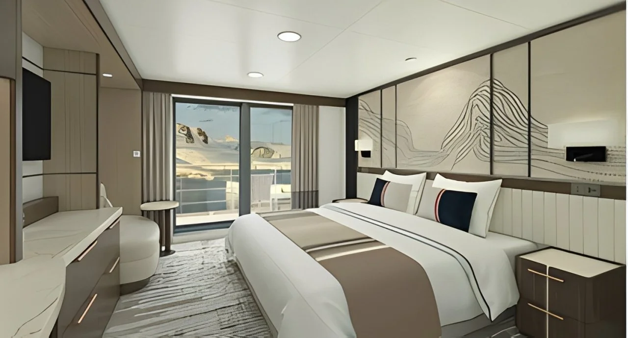 Modern hotel room with a large bed, artwork above the headboard, and sliding glass doors leading to a balcony with ocean view.