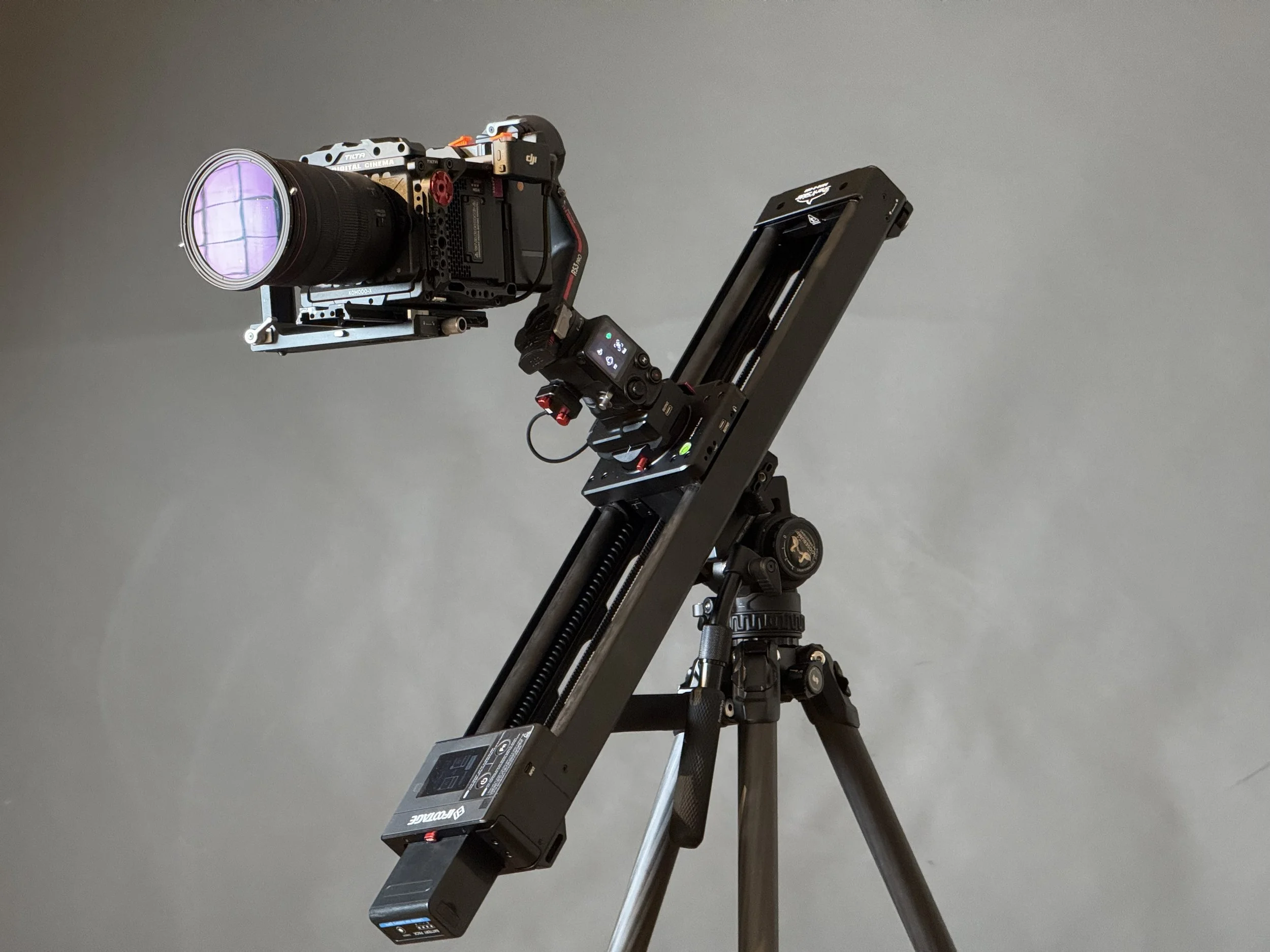 Professional camera mounted on a stabilizer tripod against a plain gray background.