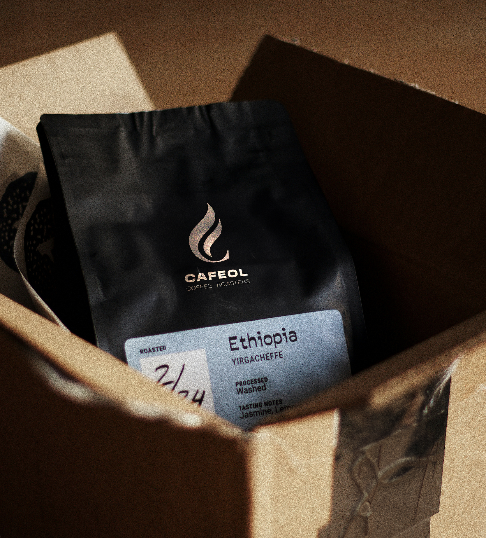 A bag of Cafel coffee roasters Ethiopia Yirgacheffe coffee on a wooden surface with a label showing tasting notes of jasmine and lemon.