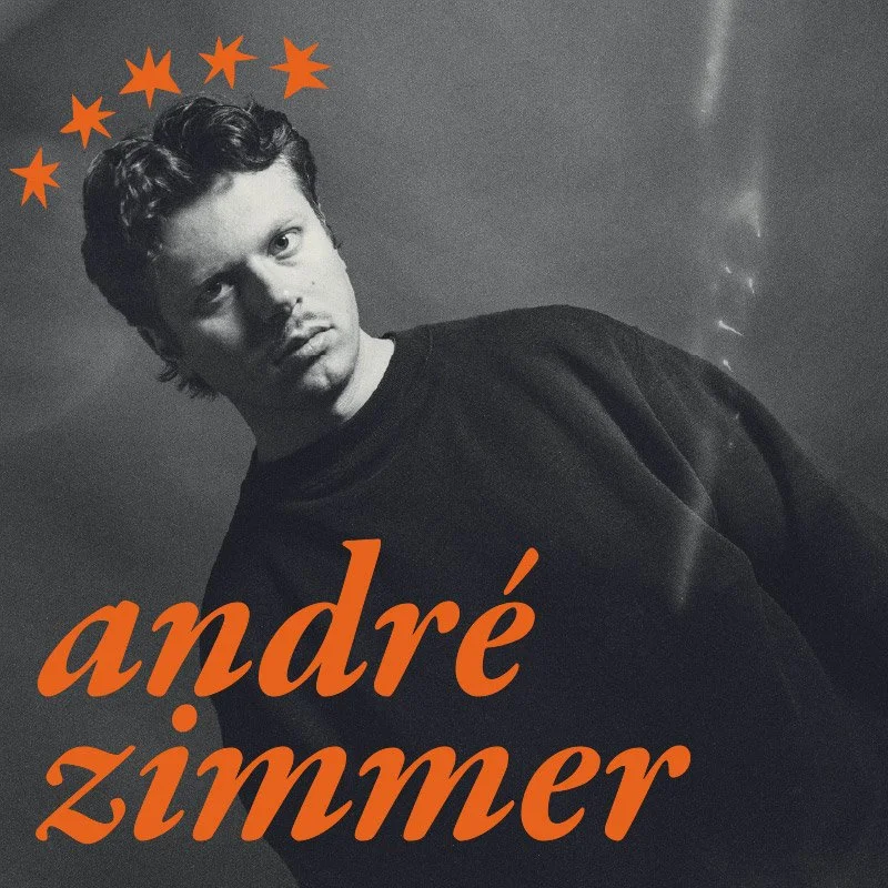 Schwarz-Weiß-Foto eines jungen Mannes mit dunklem Haar, der nach links schaut, mit roten Sternen über seinem Kopf und dem roten Text 'andré zimmer' darunter.