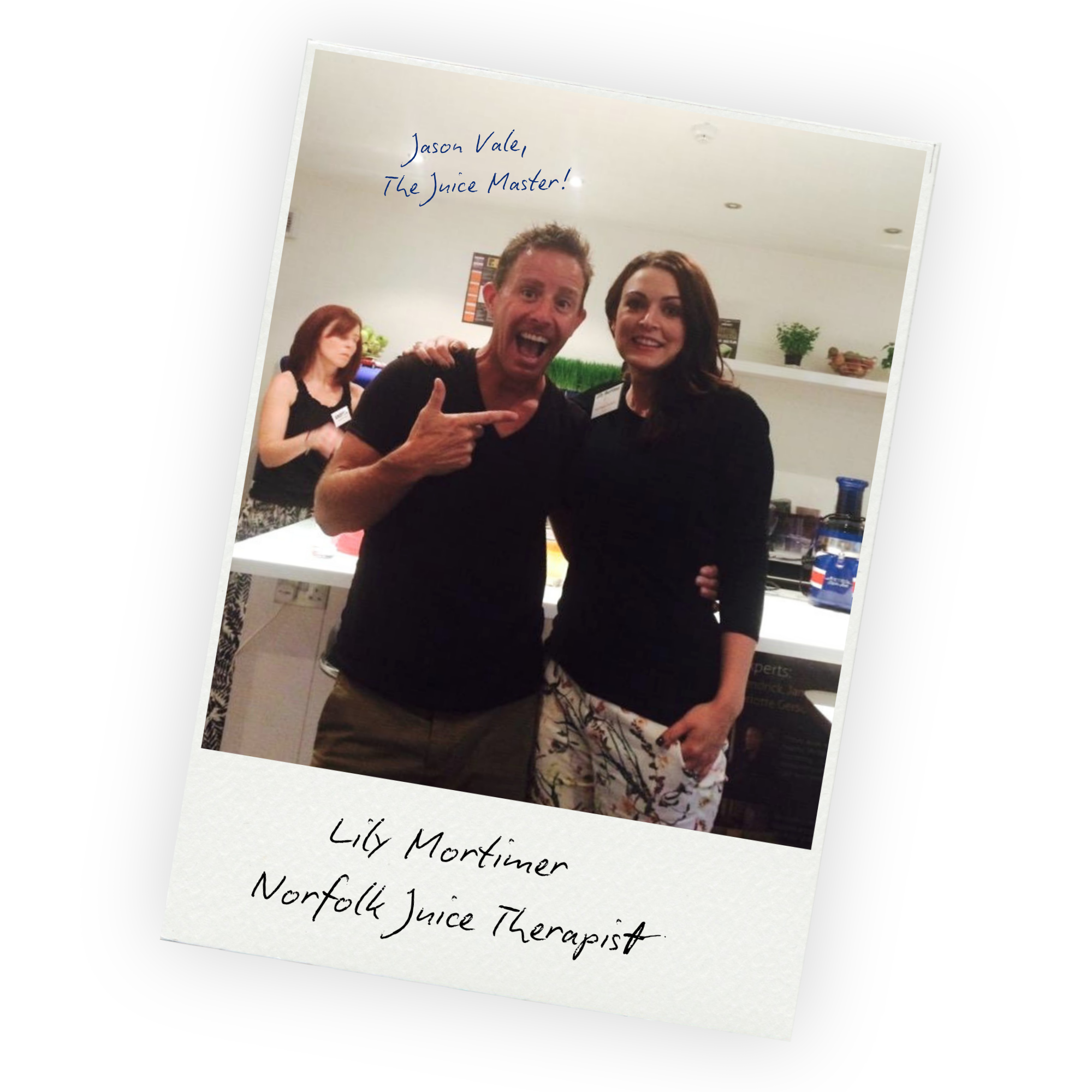 A photo of a man and woman smiling at the camera at an event, with a woman in the background and a sign that reads Lily Mortimer, Norfolk Juice Therapist.