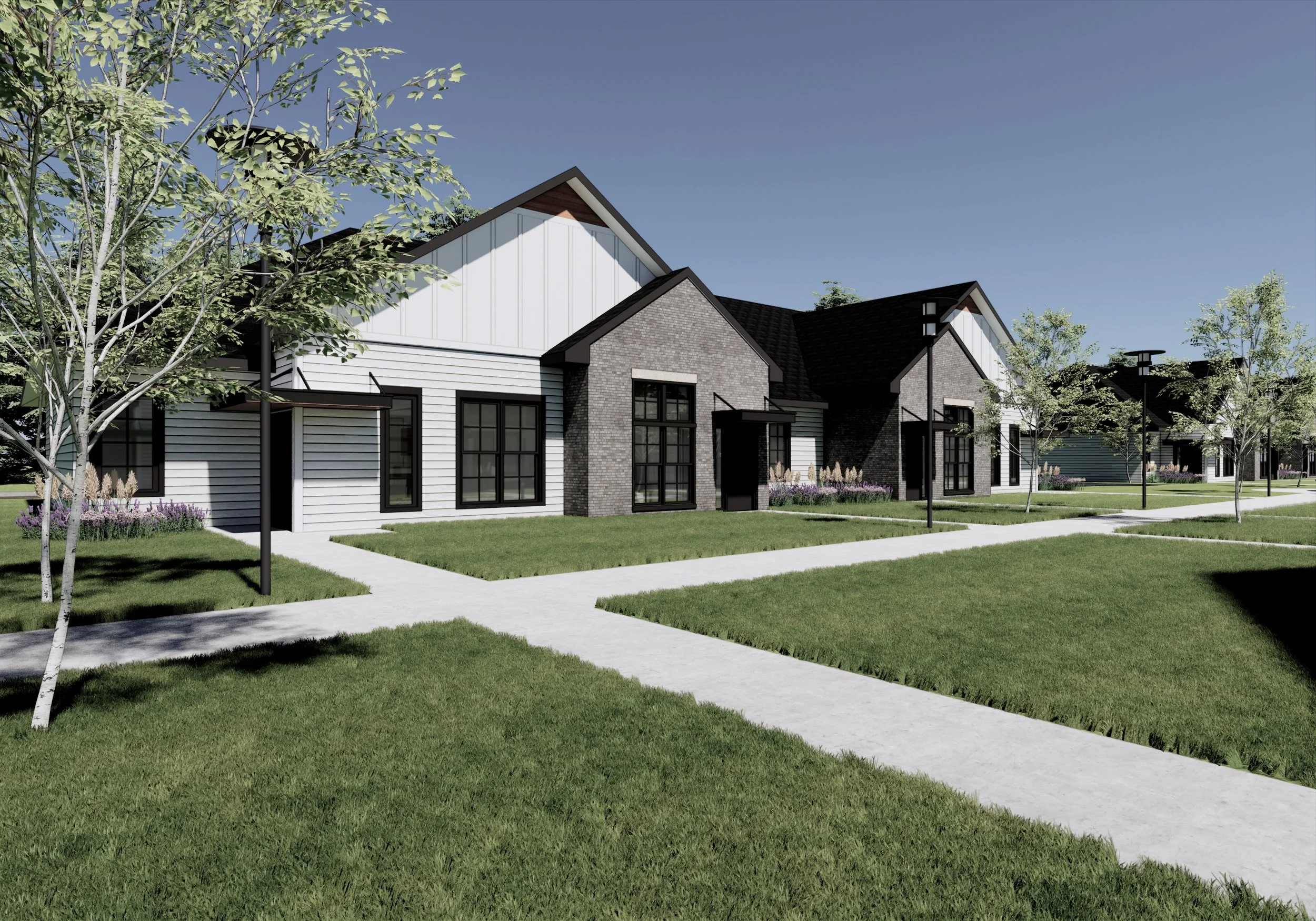 A modern residential neighborhood with houses featuring dark roofs, brick and siding exteriors, and large windows, surrounded by green lawns, trees, and sidewalks under a clear blue sky.