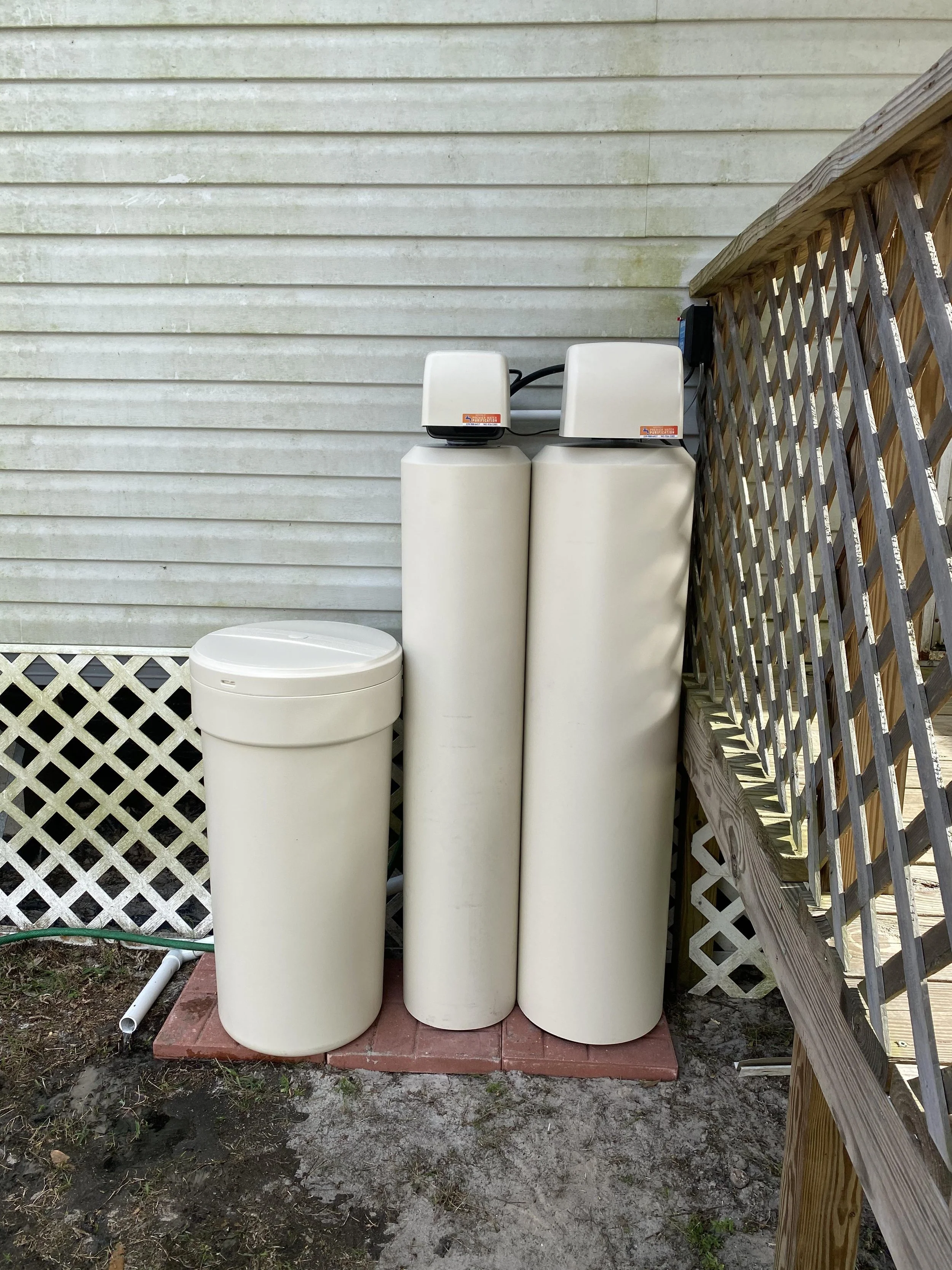 Three large beige water filtration tanks. 