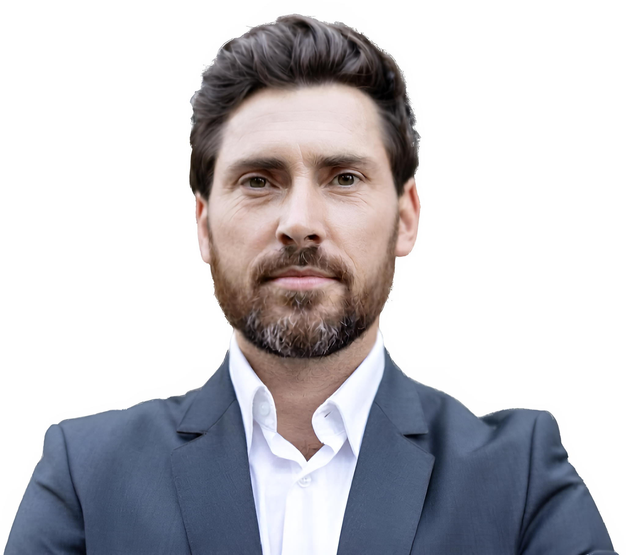 Close-up of a man's face, showing his dark brown hair, beard, and mustache, wearing a gray suit jacket and a white shirt against a black background.