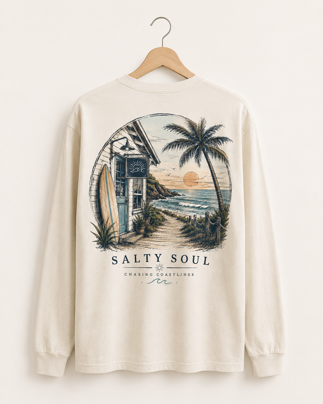 Long sleeve shirt with beach scene and text saying 'Salty Soul, Chasing Coastlines' printed on the back