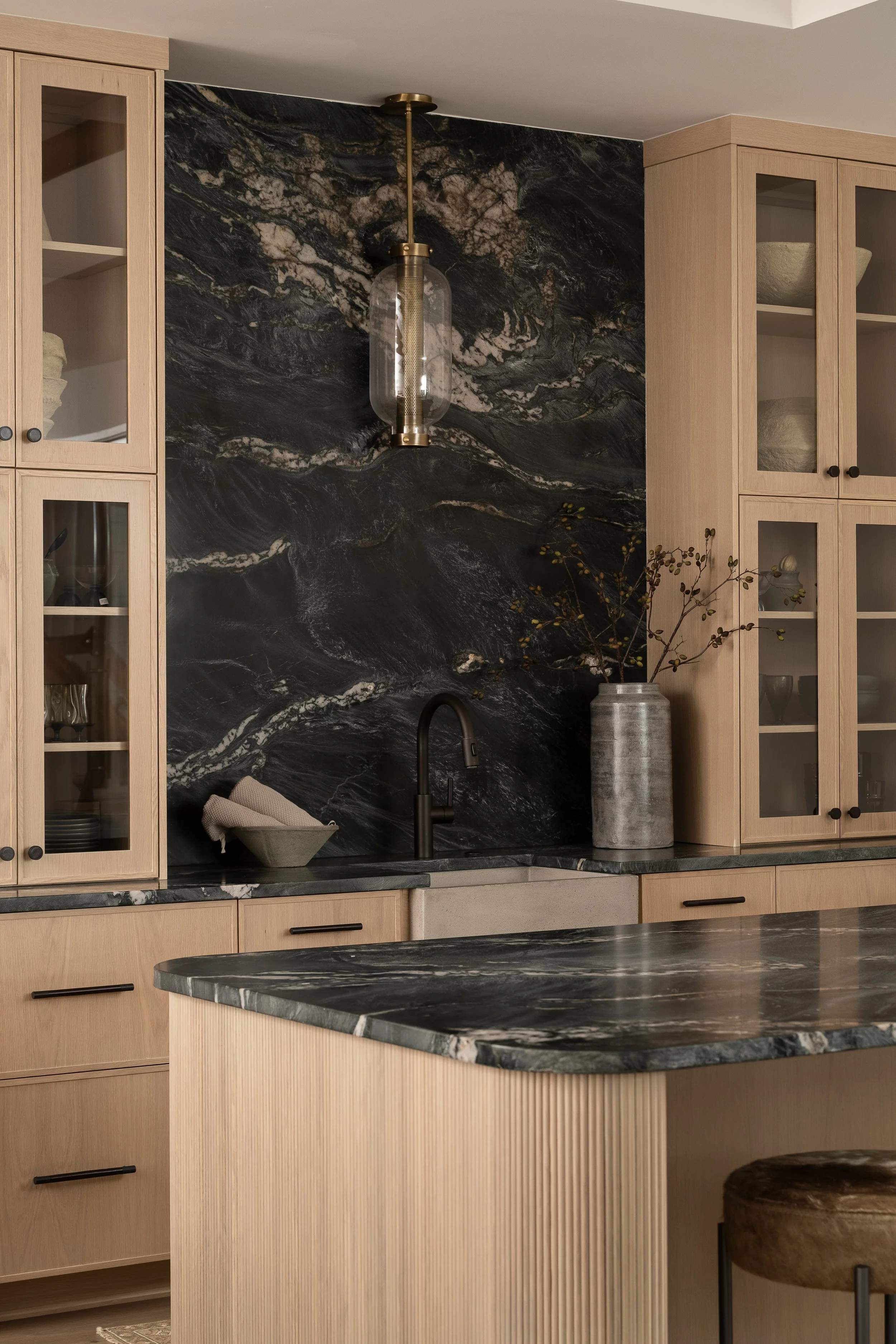 Reeded island paired with a dramatic stone slab and custom slim shaker cabinetry.