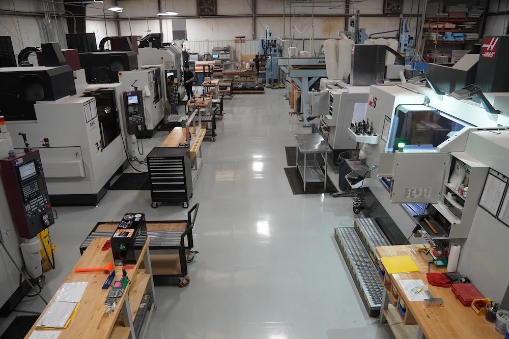 View of a manufacturing workshop with multiple CNC machines, workbenches, and tools. manufacturing company Winston-Salem history