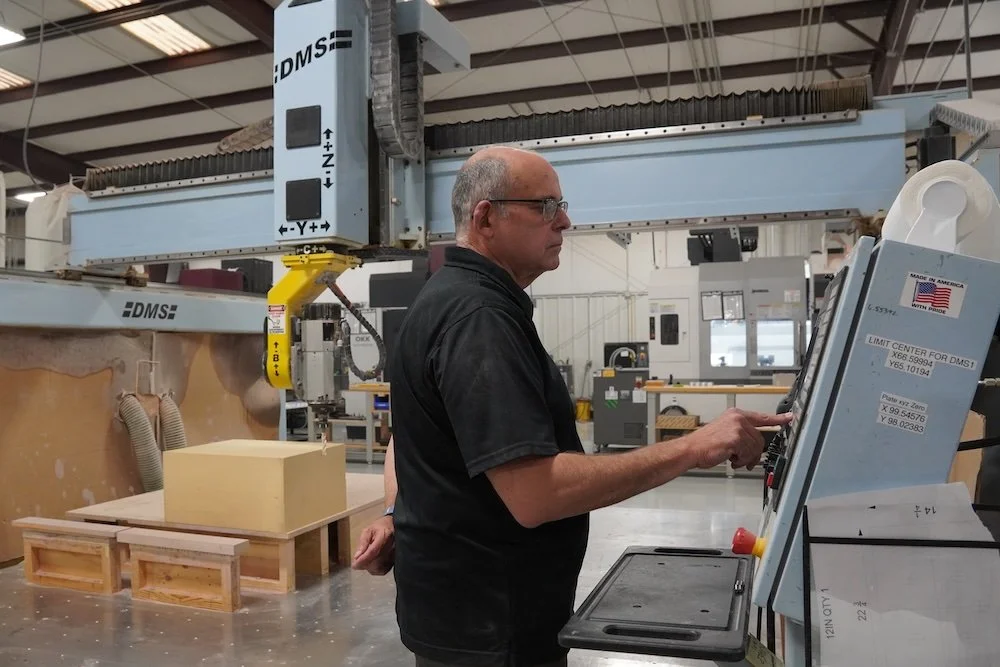 Man operating CNC machine in manufacturing workshop. manufacturing company Winston-Salem history