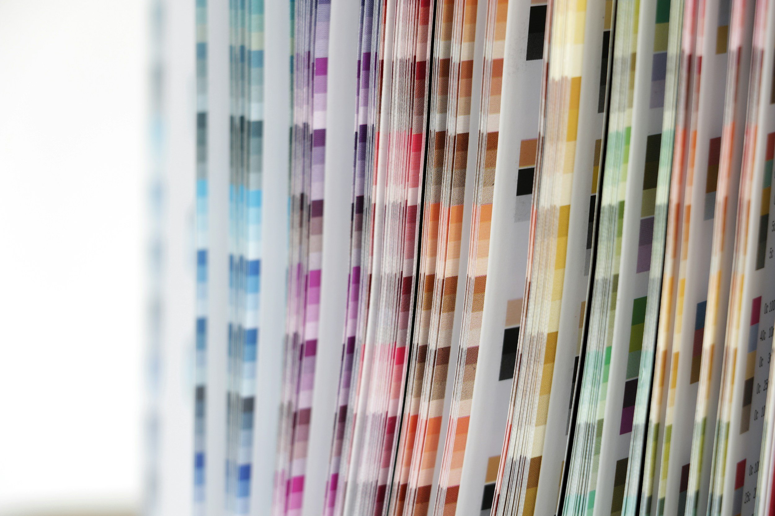 Colorful printed pages aligned vertically on a shelf.