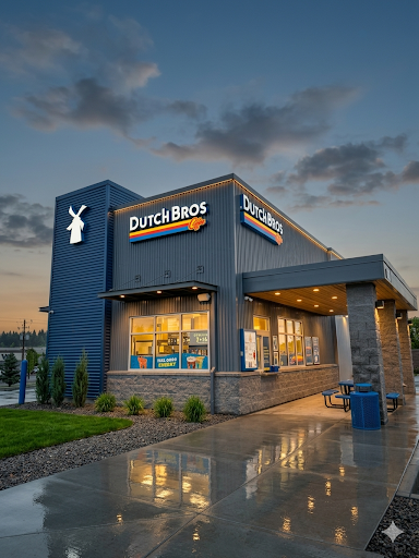 Dutch Bros coffee shop at dusk with a lit sign and outdoor seating area