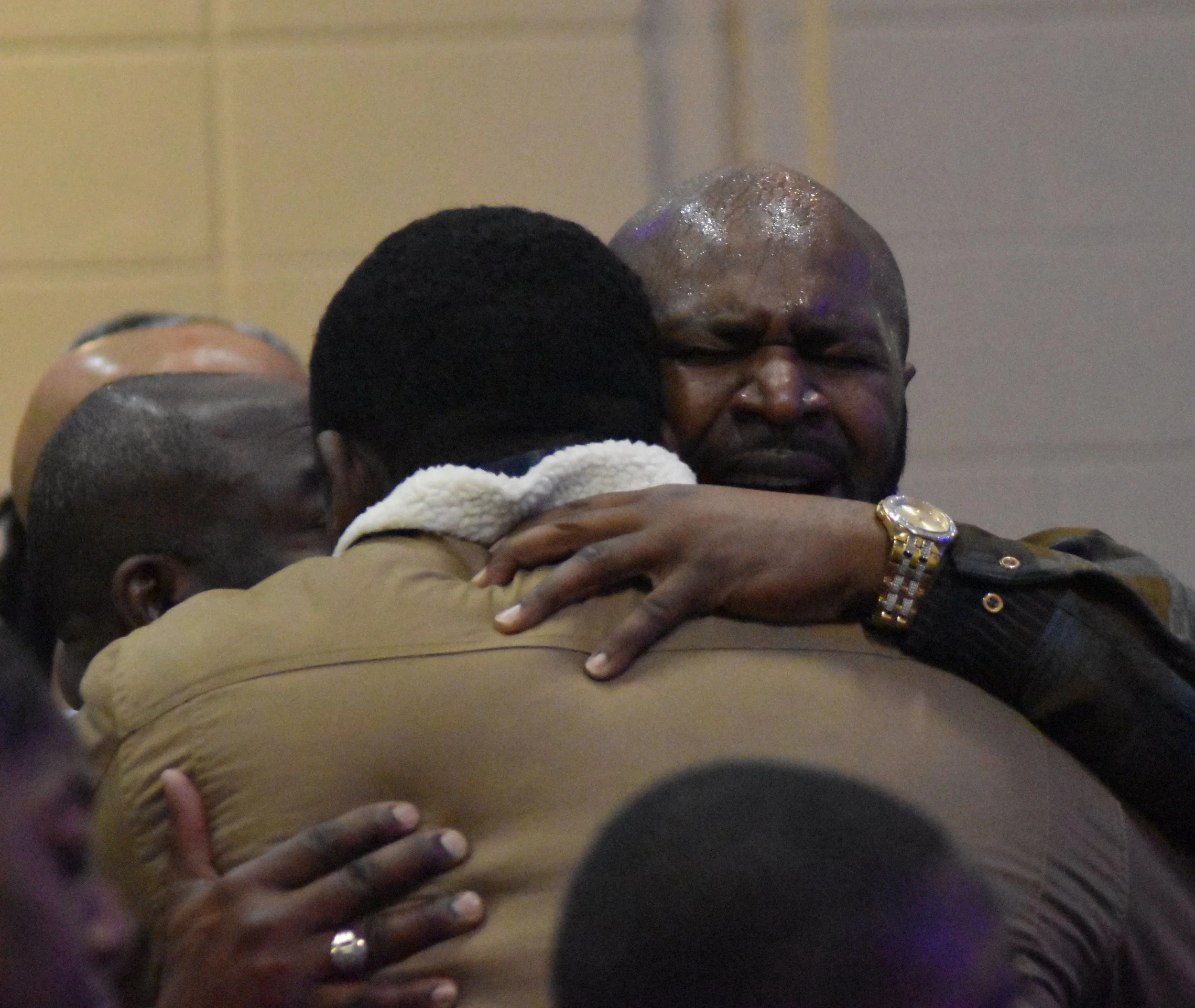People embracing and comforting each other in an emotional moment.