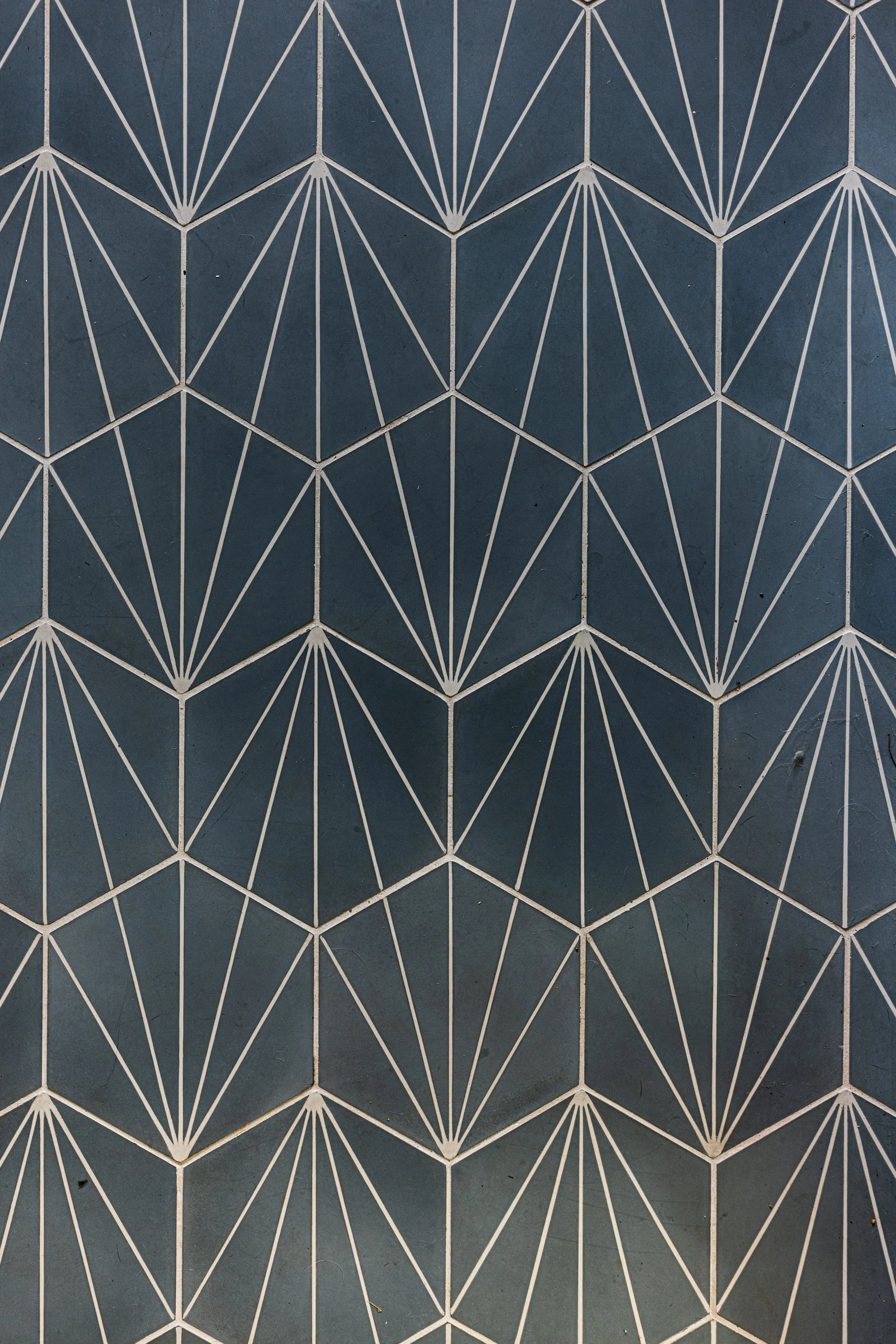 Close-up of geometric patterned ceramic tiles in shades of dark blue and white with a starburst design.
