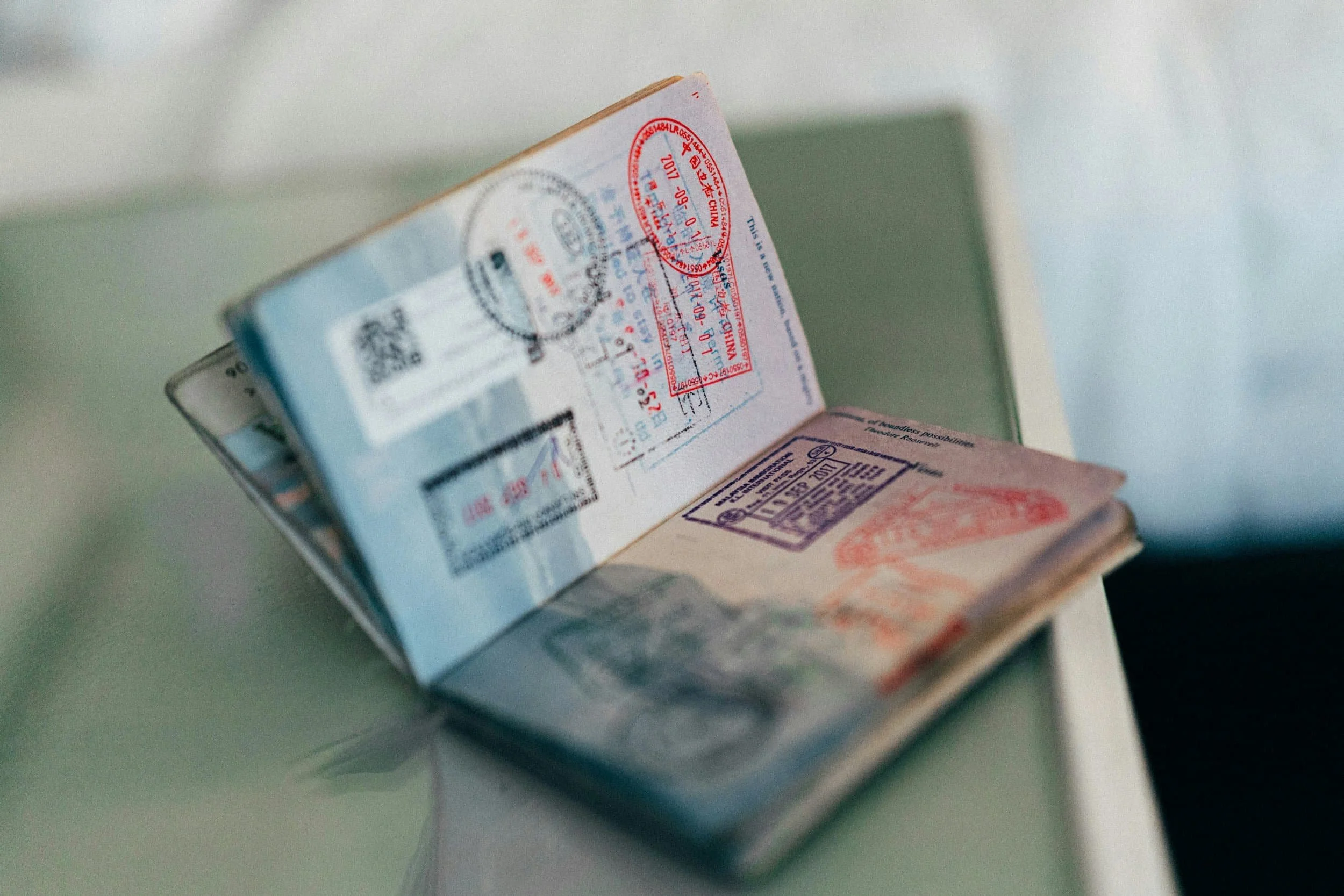 An open passport filled with colorful international travel stamps, representing the journey to a confident new smile with Gil Orthodontics.
