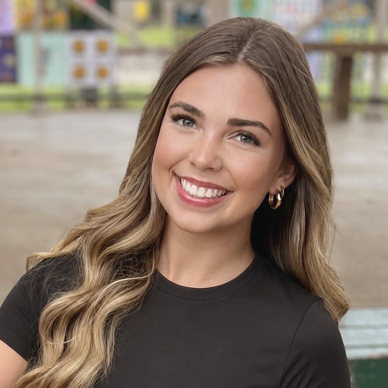 A smiling young adult woman displaying her beautiful, straight teeth after treatment at Gil Orthodontics.