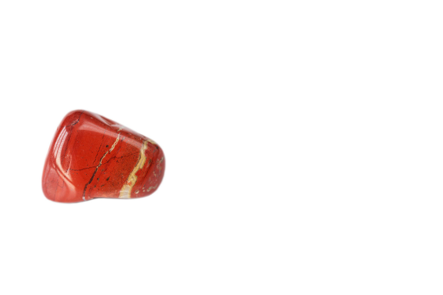 Close-up of a polished red gemstone with natural veining and color variations.