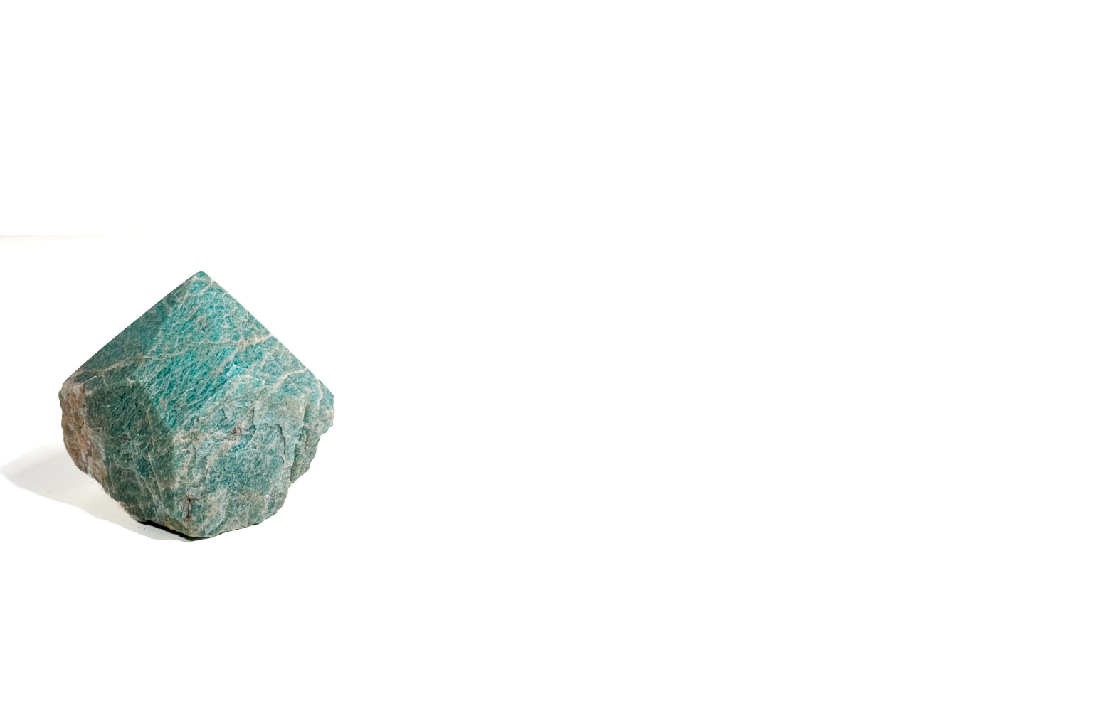 A single turquoise and gray mineral or stone on a white background with a shadow.