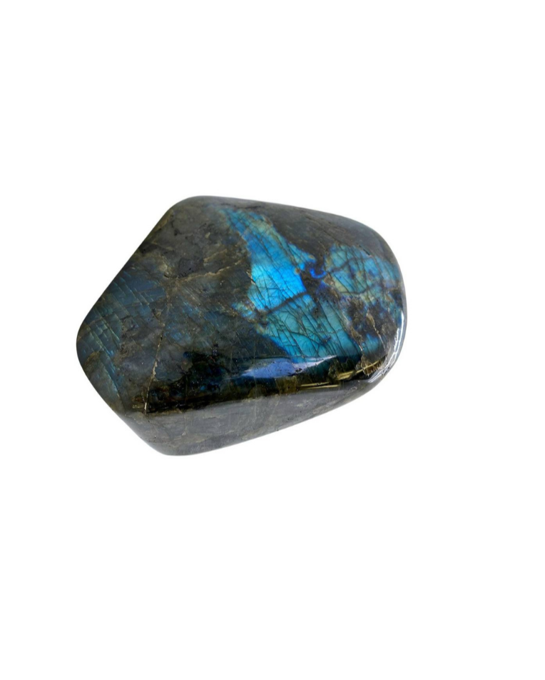 A polished labradorite stone with iridescent blue and green flashes, placed on a white background.