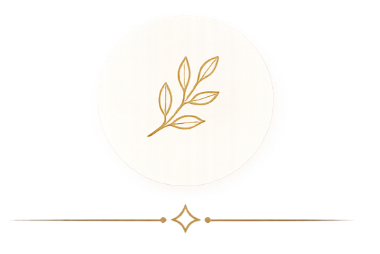 A round, white soap with a gold leaf design on top, placed on a clear surface with a gold chain underneath.
