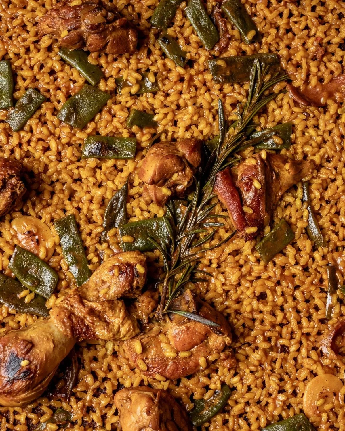 Paella con pollo, verduras y romero
