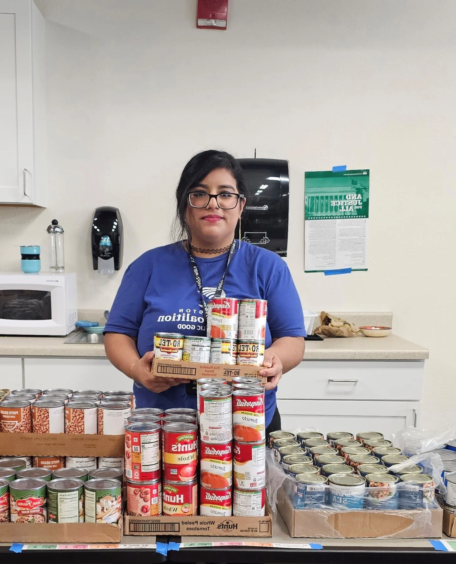 Photo of a WACC volunteer holding cans of food.