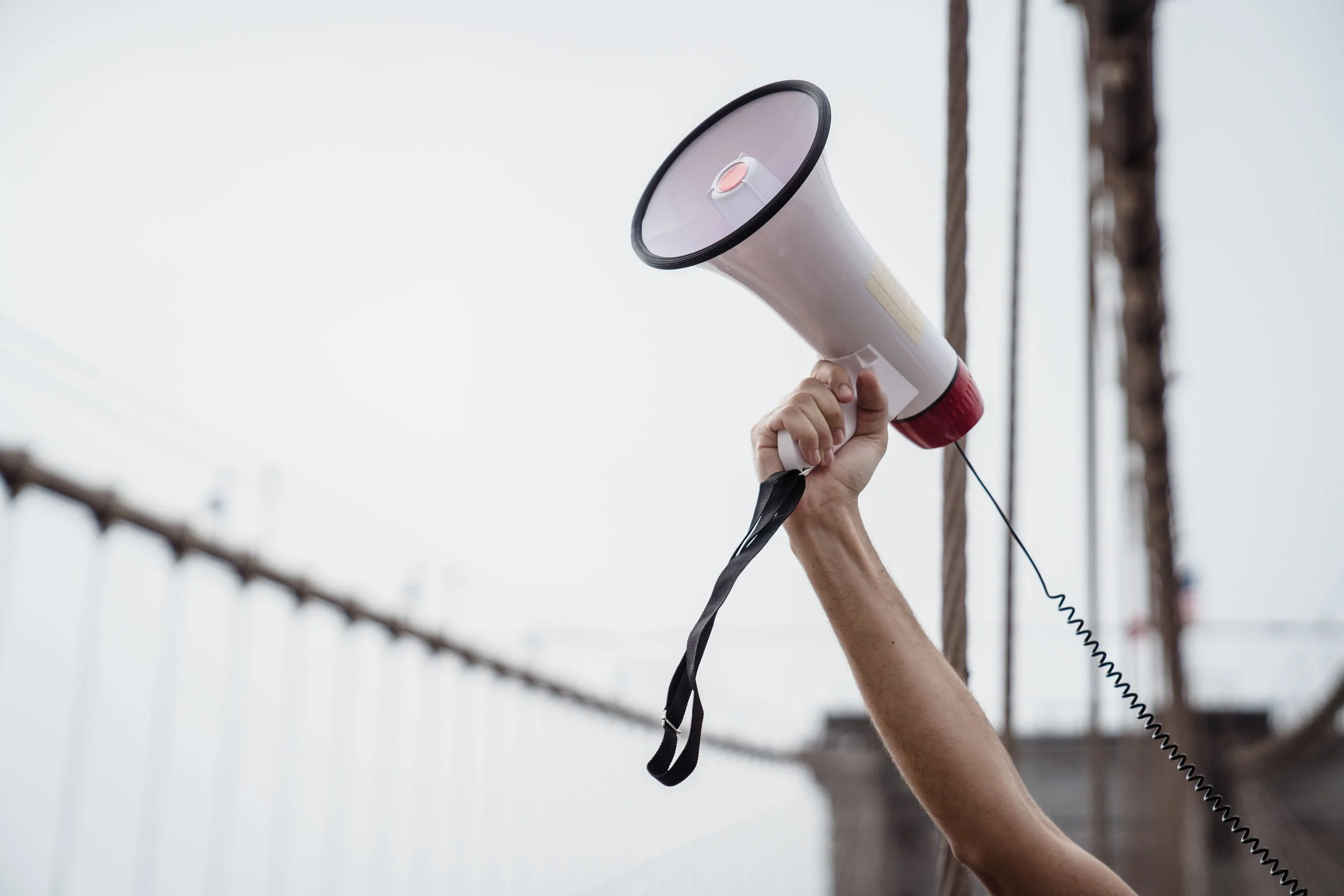 Hand holding up a megaphone.